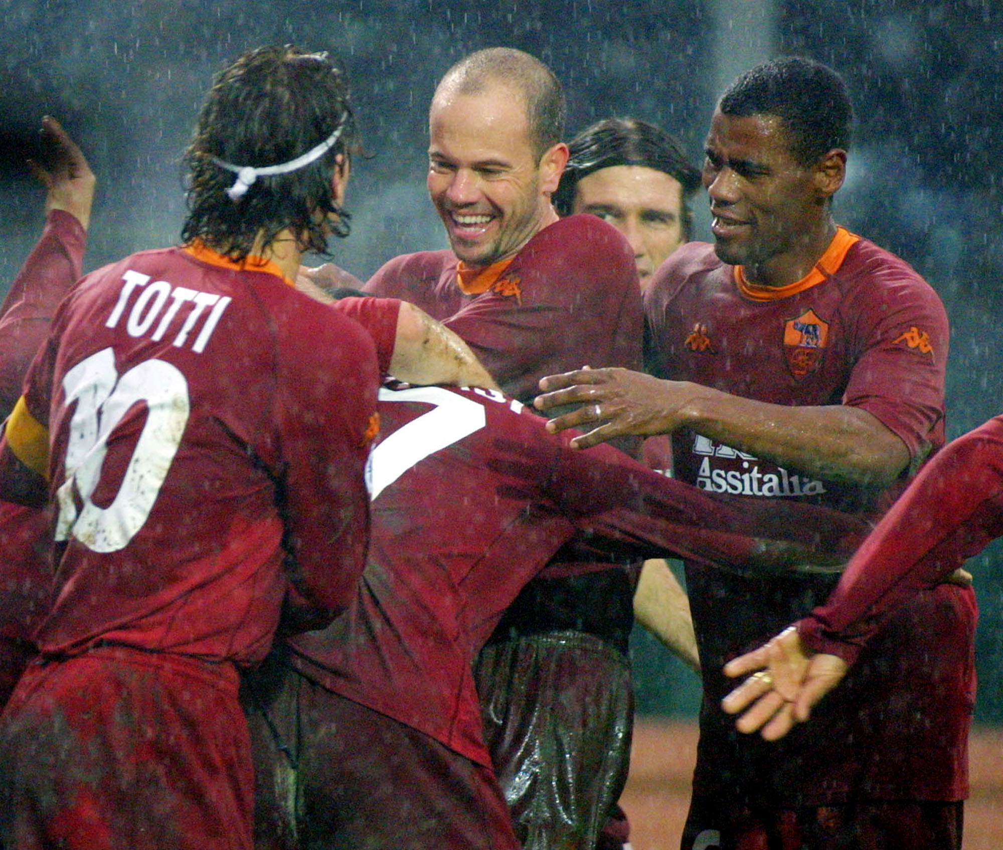 AS Roma's players Francesco Totti, left, Antonio Carlos Zago of Brazil, center, and Aldair of Brazil, celebrate under the rain after Damiano Tommasi, center, back to camera, scored second goal for Roma during an Italian first division soccer match Atalanta vs AS Roma at the Bergamo stadium, Italy, Sunday, Jan. 7, 2001. AS Roma won 2-0, mantaining a comfortable lead in the Serie A  standings. (AP Photo/Felice Calabro')