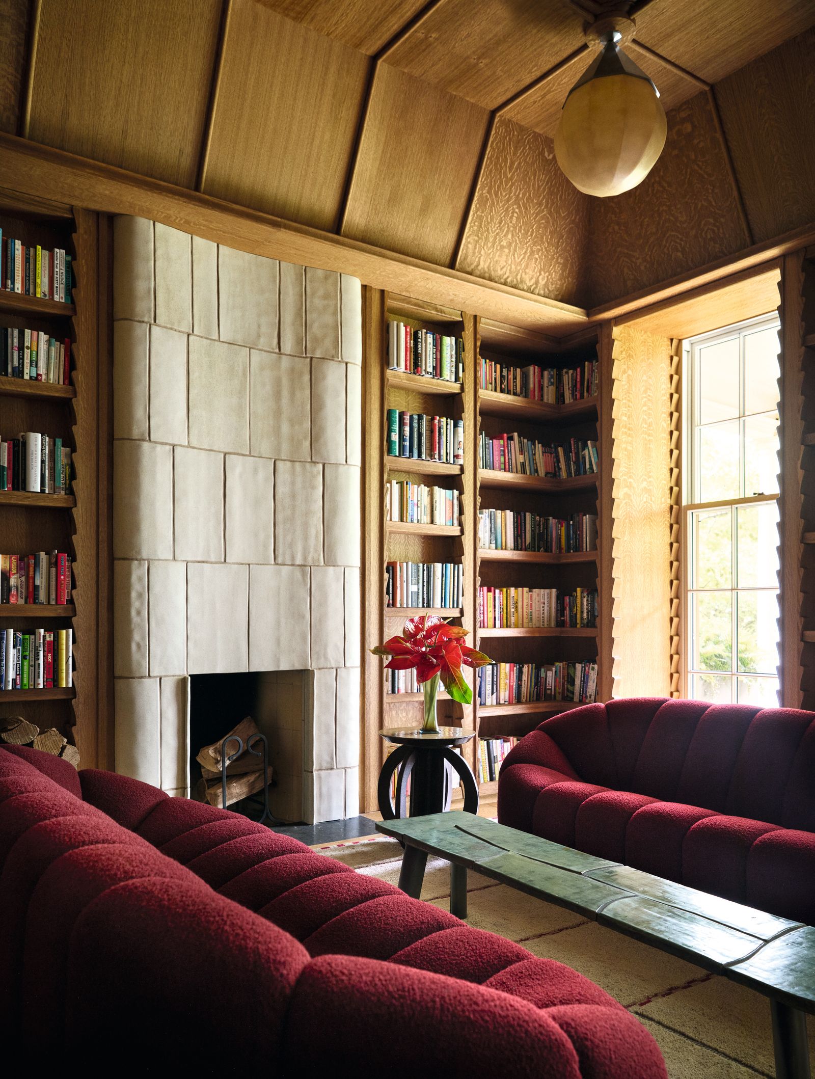 Biblioteca librerie libri camino divani rossi soffitto in legno finestra casa a toronto