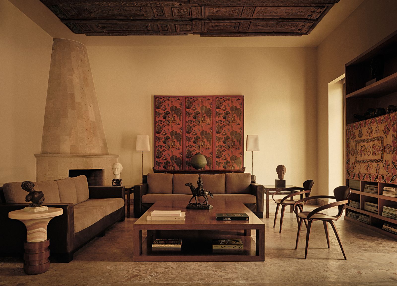 Soggiorno divani marroni con struttura in legno sedie sculture camino in pietra