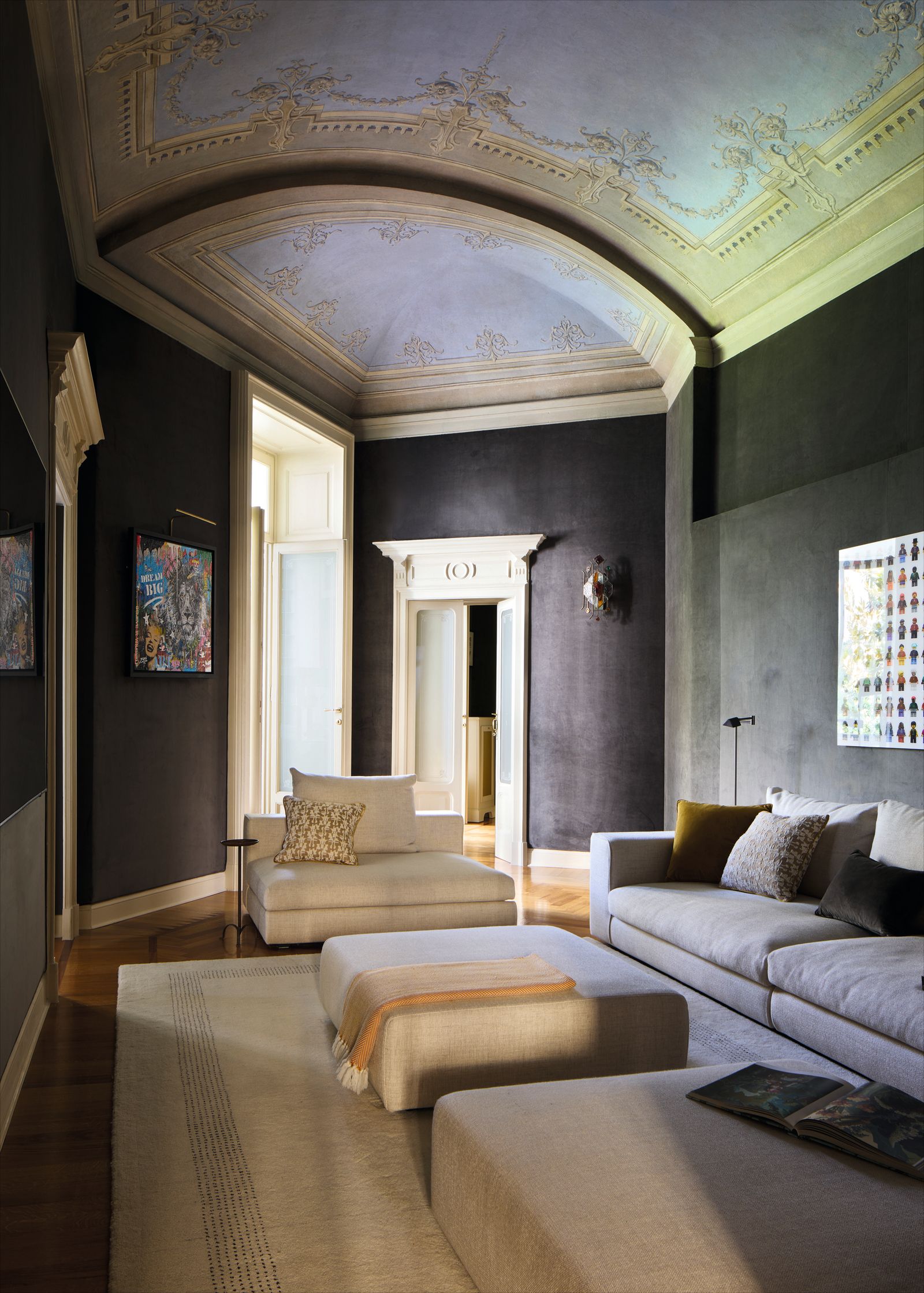 Soggiorno soffitto affrescato divano e poltrona bianchi pouf tappeto pareti scure