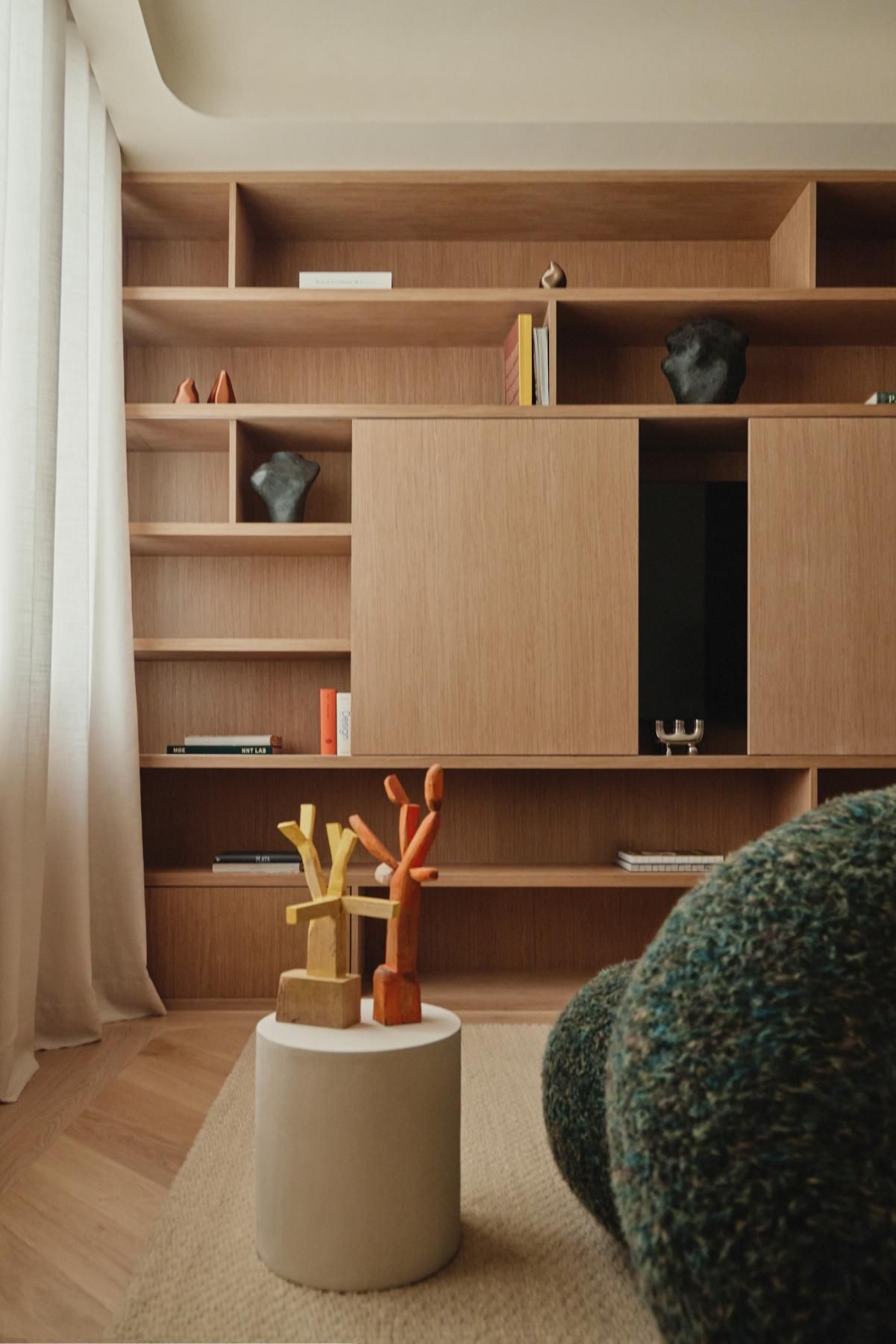 libreria in legno su misura con scaffali tavolino d'appoggio con sculture