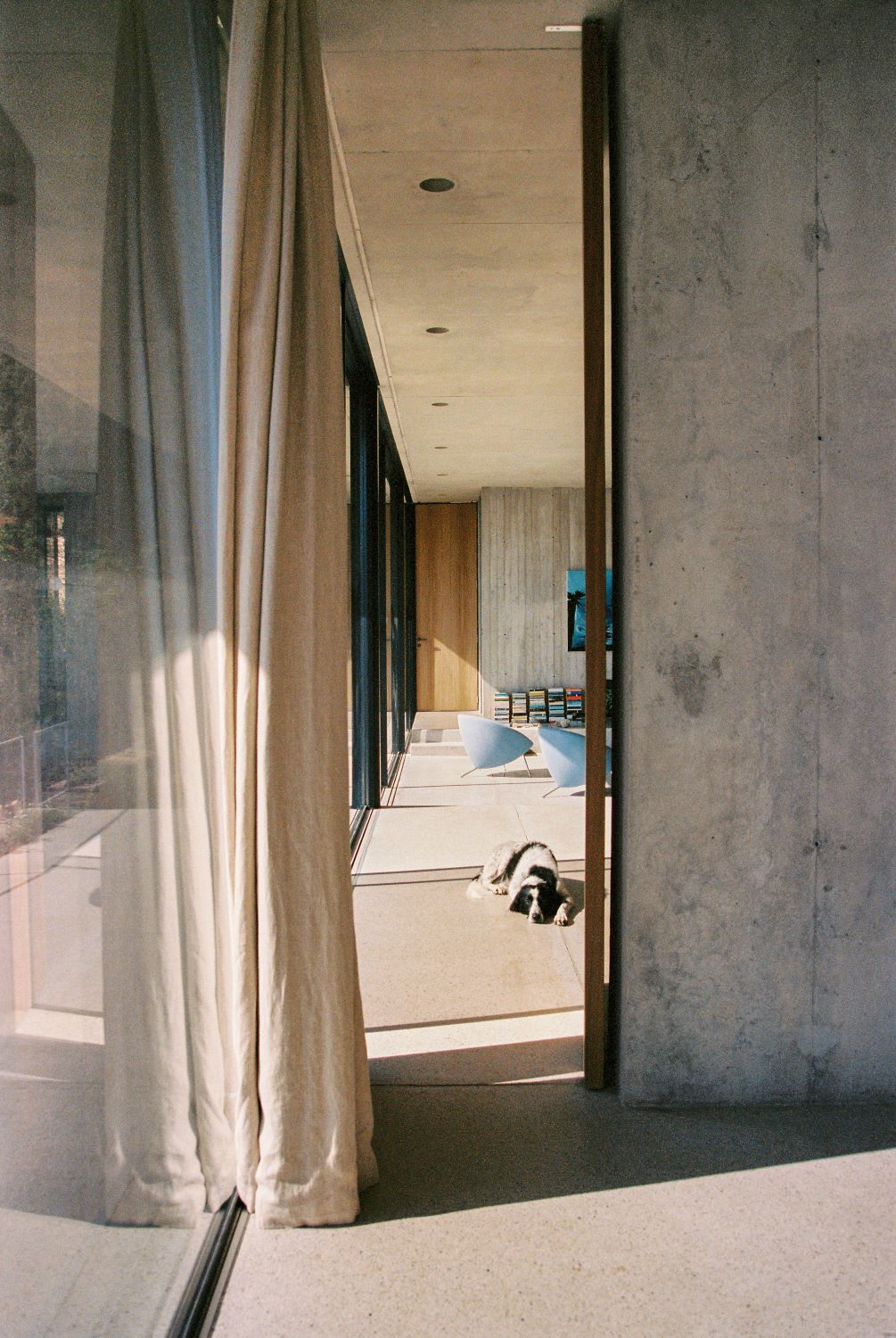 Scorcio di un salotto, tenda beige, grossa vetrata sulla sinistra.