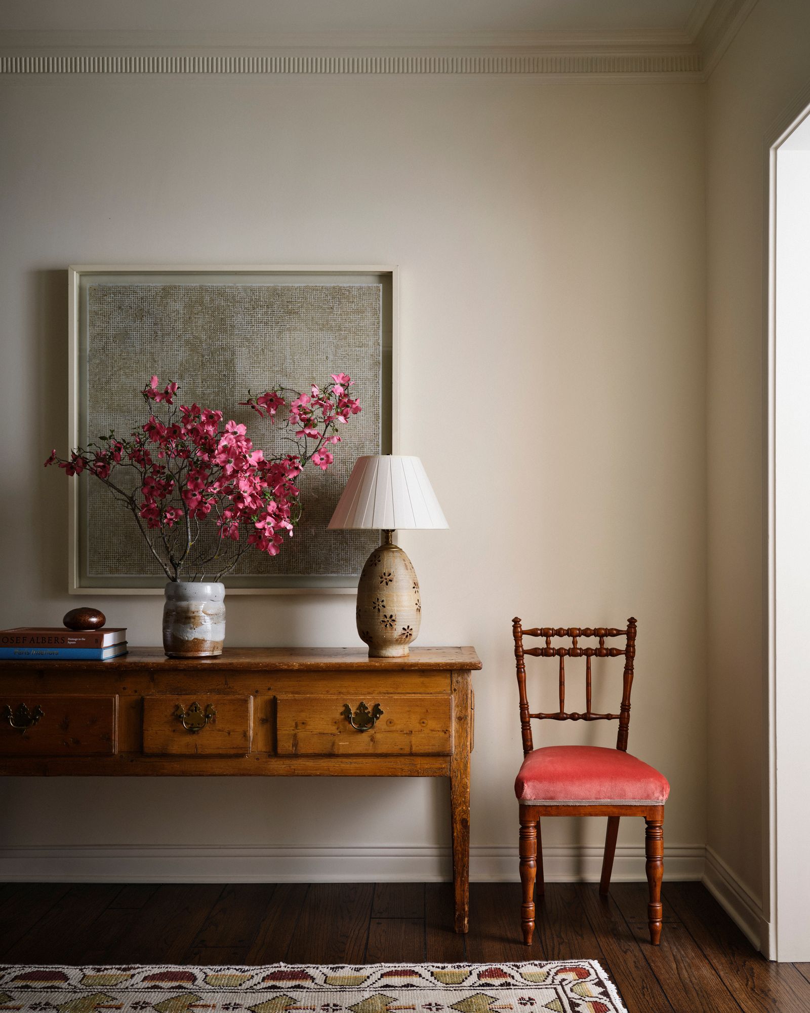 casa a Hollywood ingresso consolle vintage lampada da tavolo sedia vintage rivestita vaso con ramo di foglie rosse...