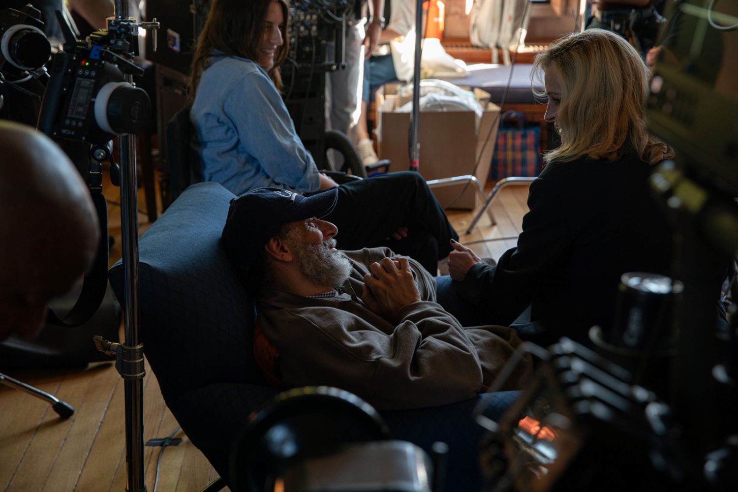 Scena sul set con attori, si intravedono telecamere e attrezzi per le riprese