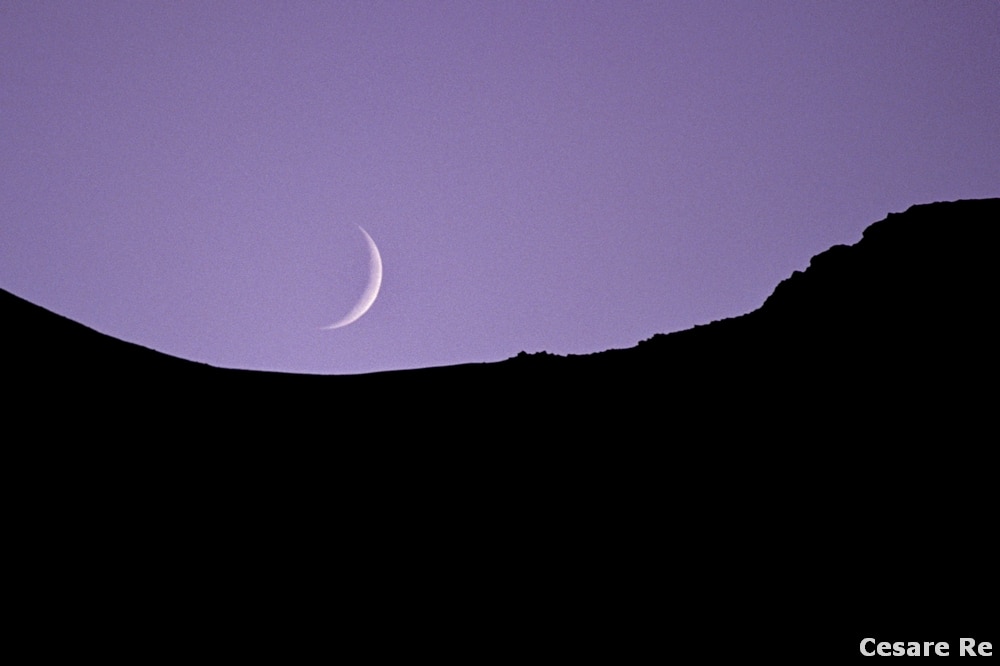 La luna, dai pressi del Rifugio Vittorio Sella. In questo caso, la scelta è diversa. Le cime sono volutamente riprese in silhouette, con la luna a spicchio. In questo caso, il dettaglio della luna non è importante, ma basta l’accenno della forma grafica, così peculiare e immediatamente identificabile. Nikon F5; Nikkor 80-200 2,8 AFD; Fujichrome Provia 100; treppiede. 