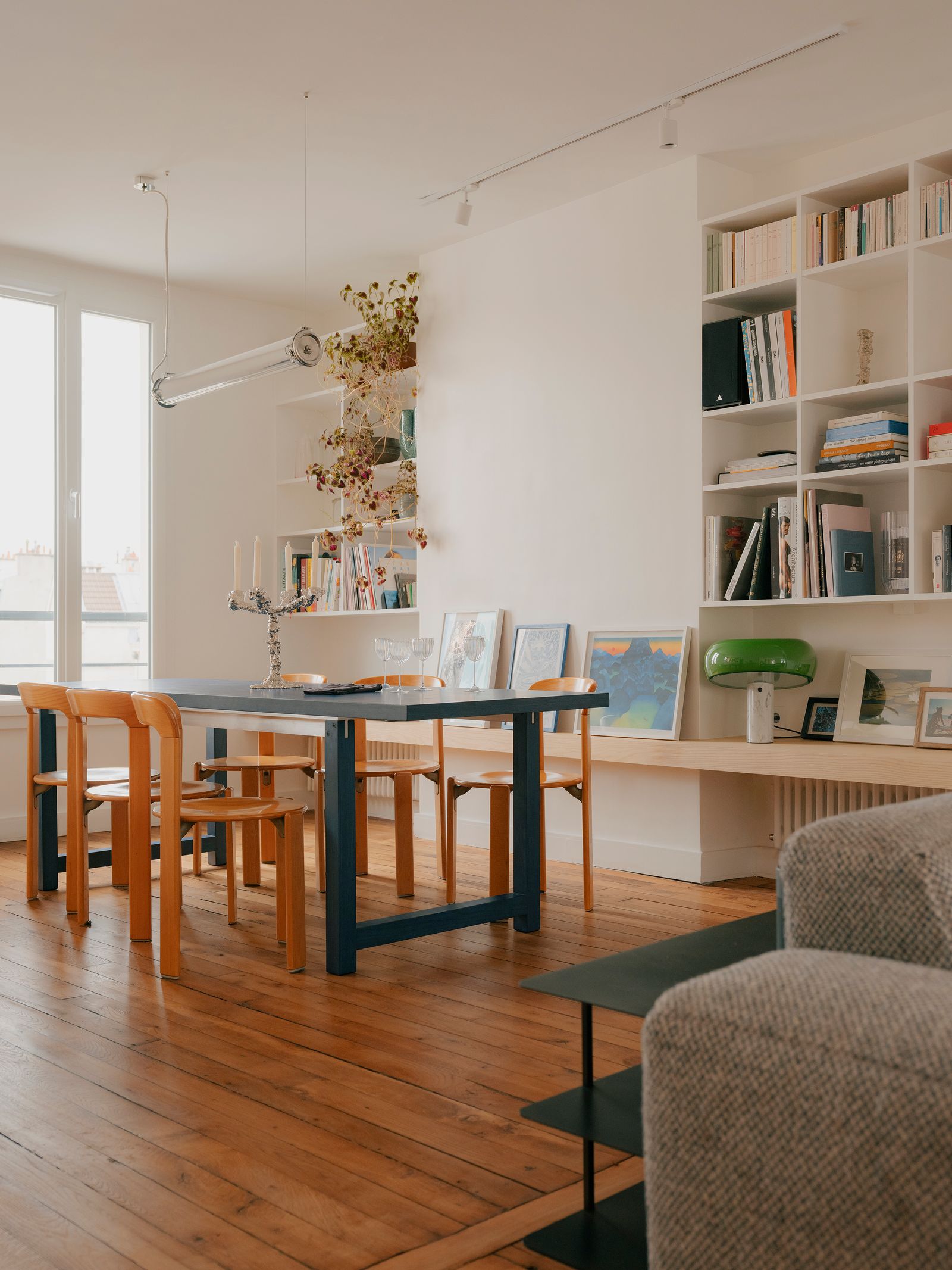 piccolo appartamento a parigi zona pranzo tavolo da pranzo blu sedie arancioni libreria panca mensole