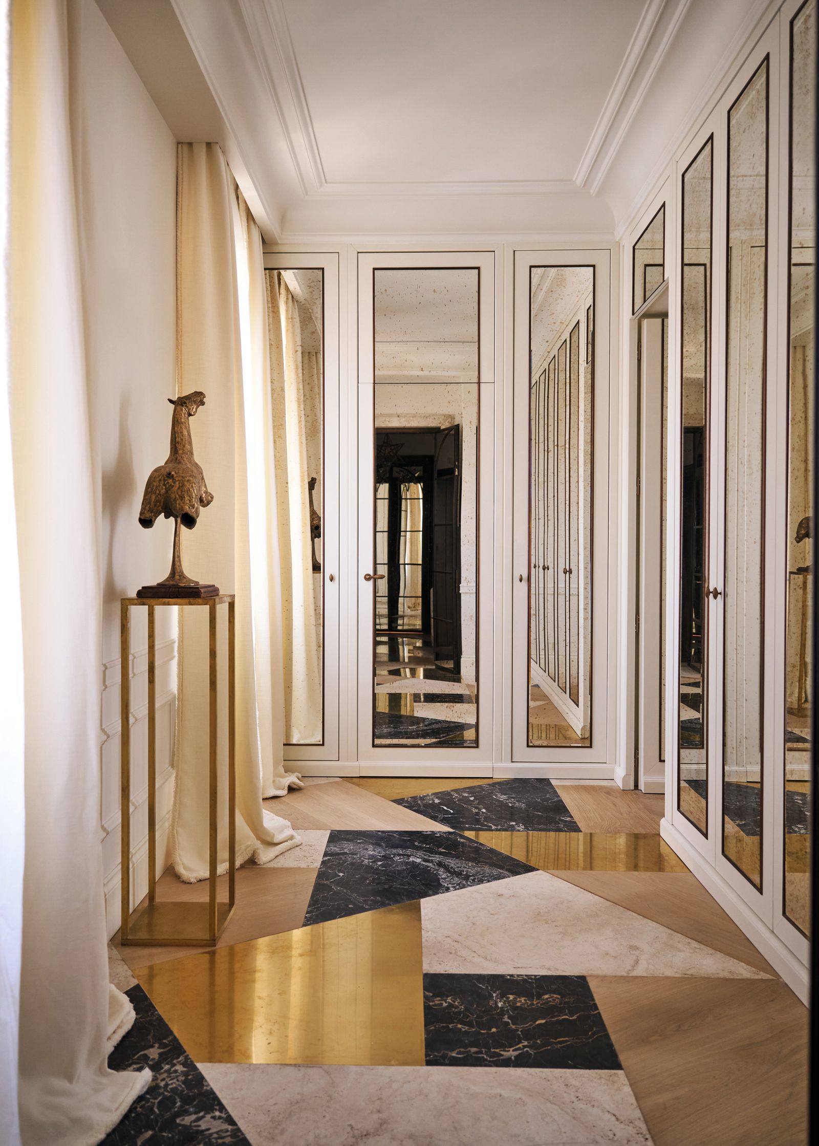 Ingresso pavimento in marmo oro bianco nero legno armadio bianco con vetri statua tende