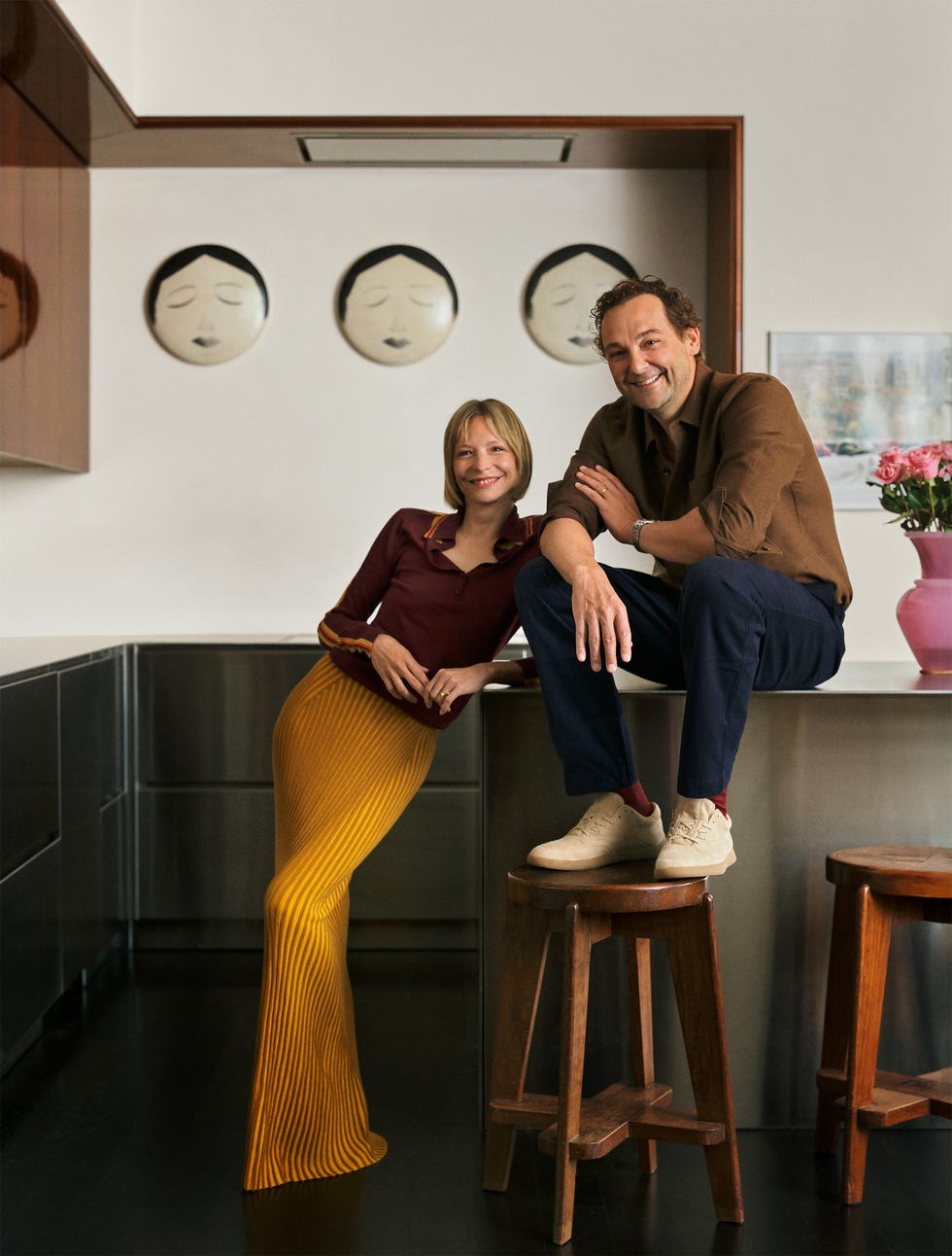 daniel-humm-annabelle-sexter-jones a couple poses in a modern kitchen, highlighting their attire and the surrounding decor.