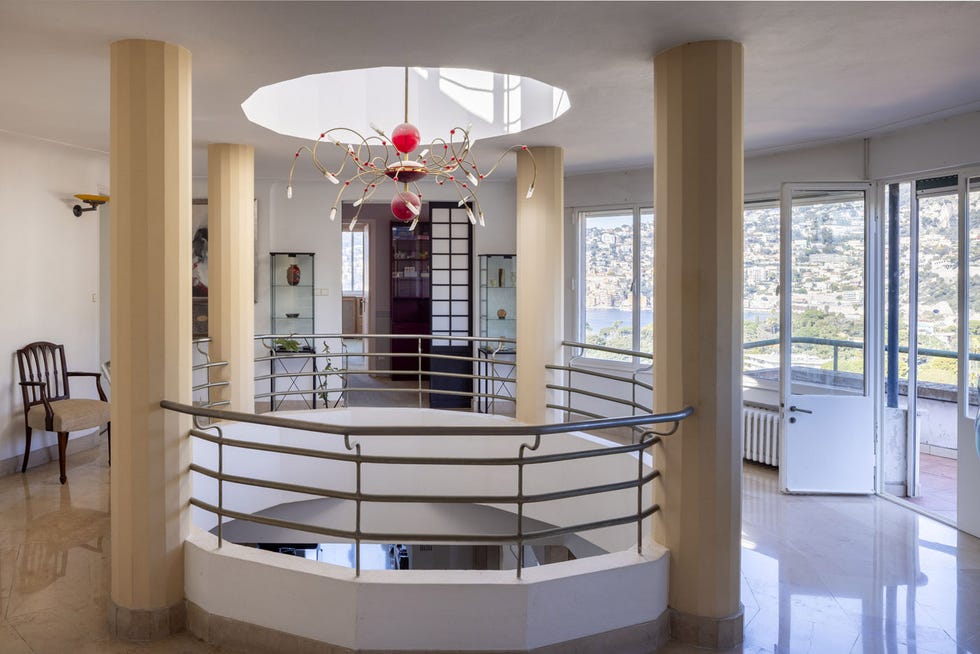 interior view of a modern space featuring a circular balcony with railing and a unique chandelier