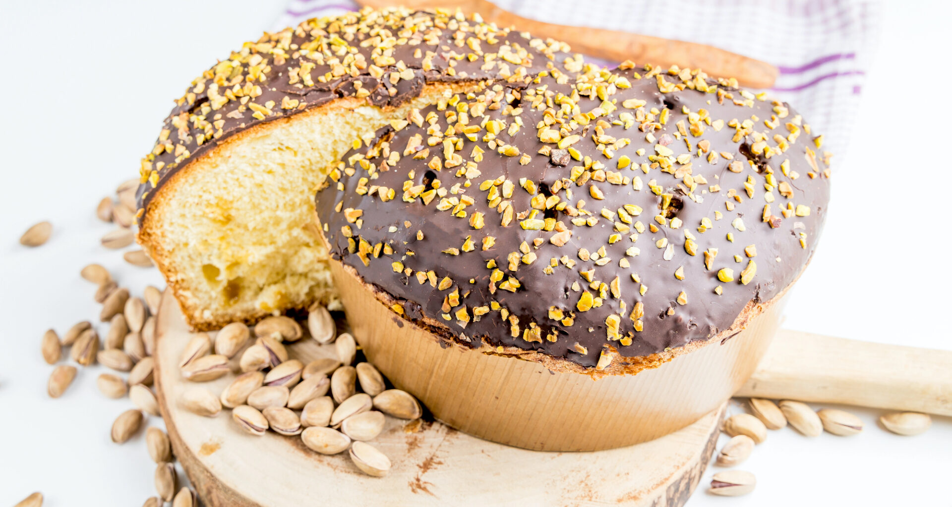 Un panettone farcito di crema al pistacchio ricoperto di cioccolato e granella di pistacchio; concept: Natale