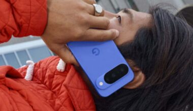 ragazzo sdraiato con cappotto rosso tiene all'orecchio google pixel 10 blu