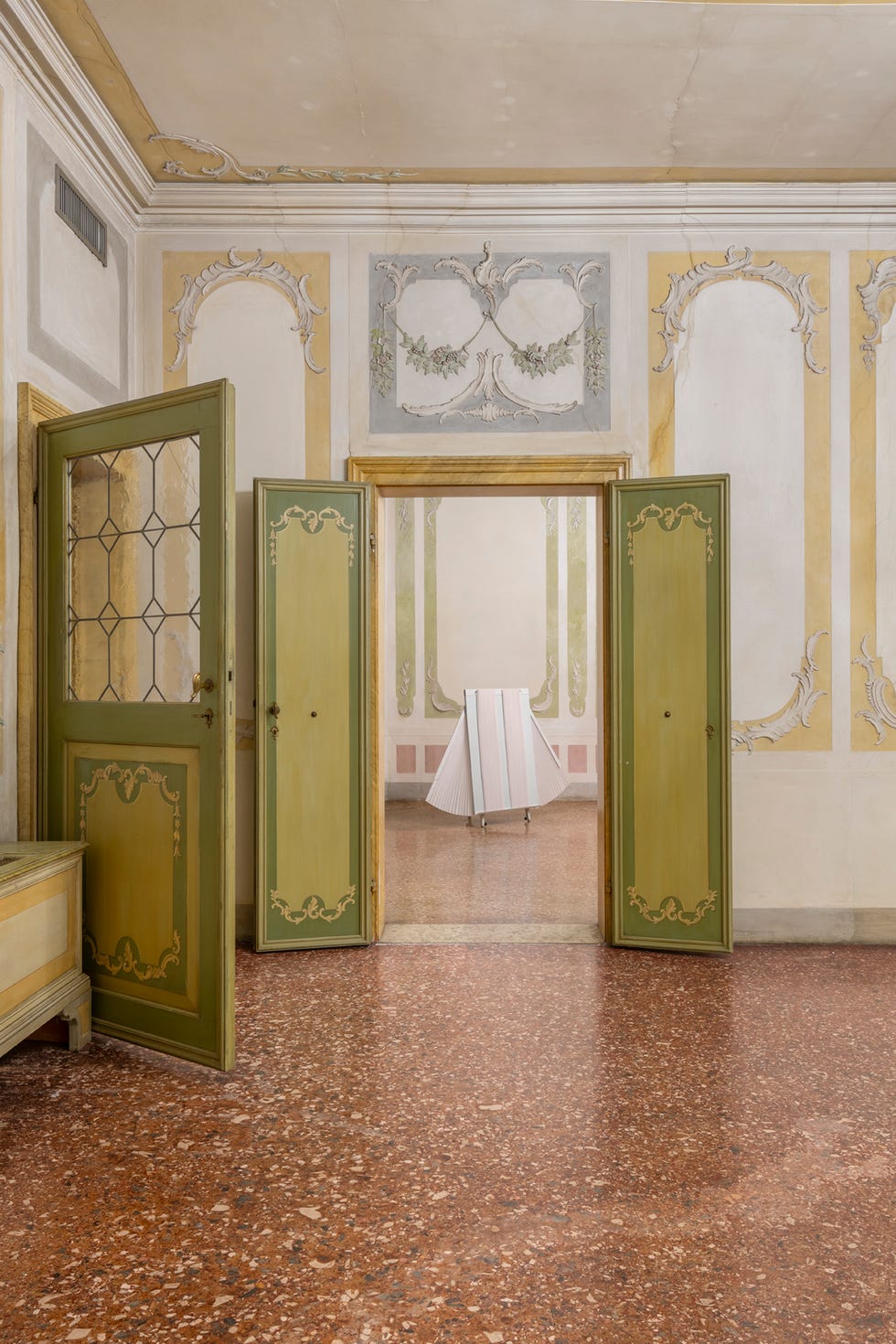 interior view of a room with multiple doors and a folding screen