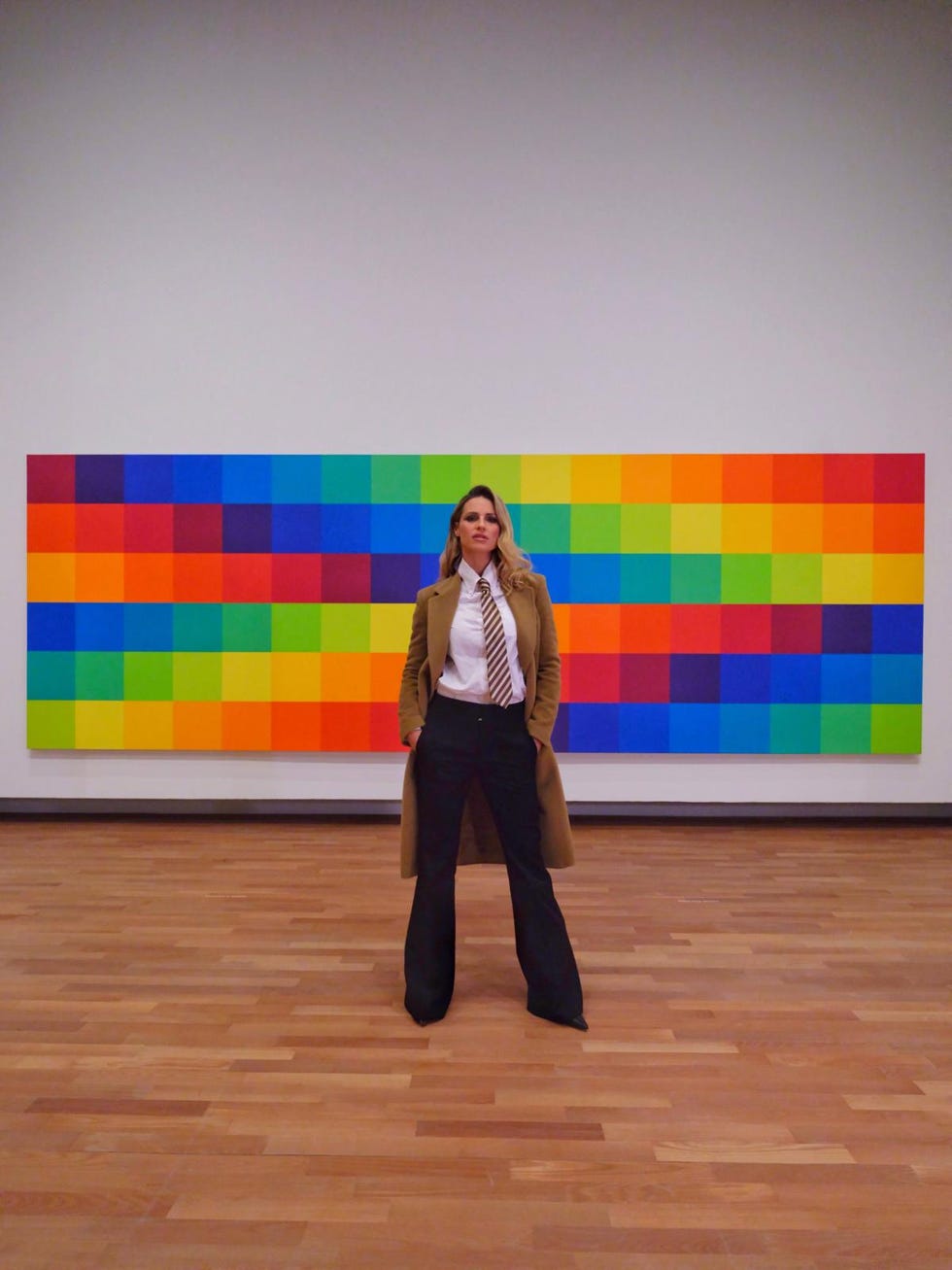 person standing in front of a colorful abstract artwork in an art gallery person standing in front of a colorful abstract artwork in an art gallery