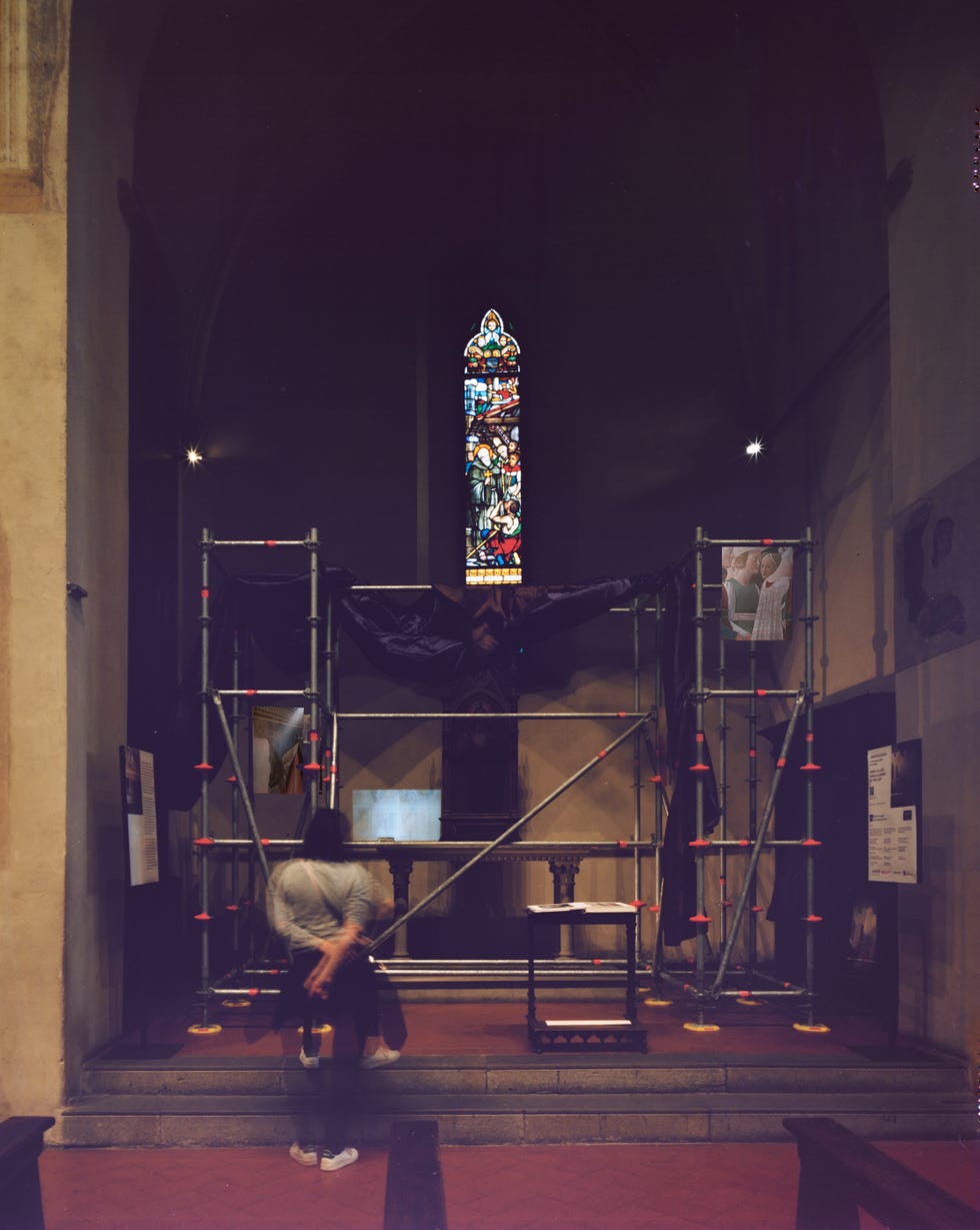 interior of a church under renovation with scaffolding and a stained glass window