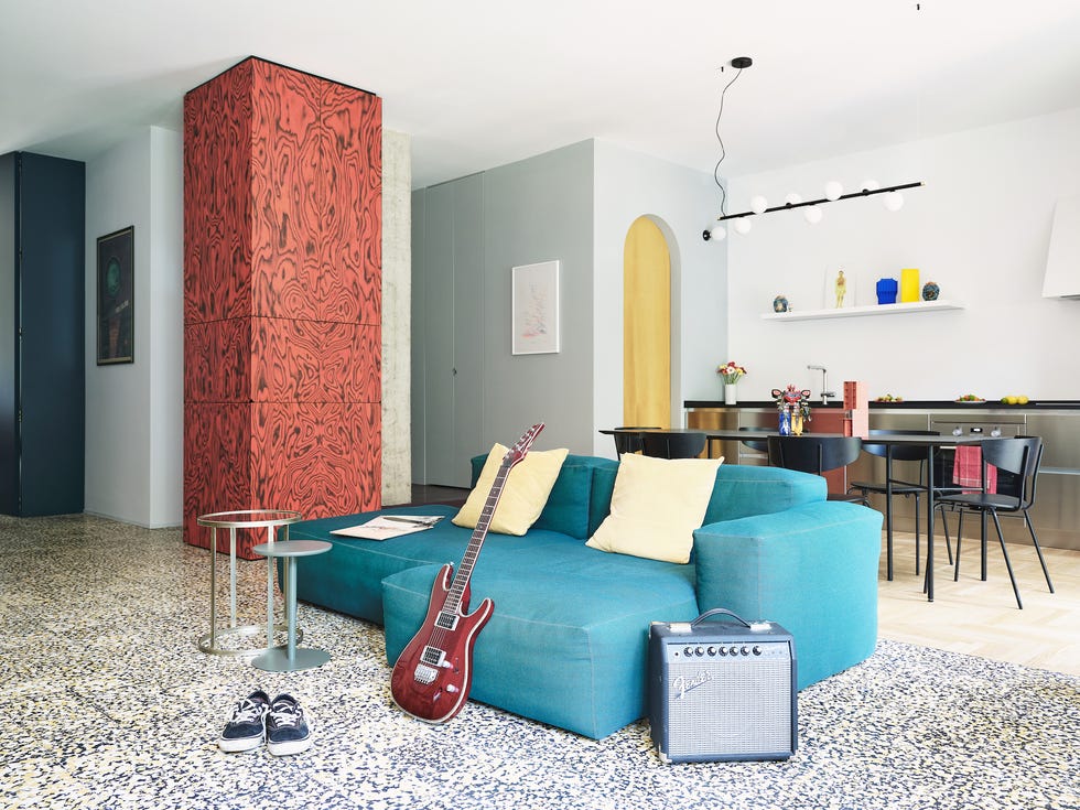 a living room with a blue couch and a guitar