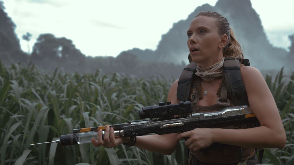 person holding a futuristic weapon in a field