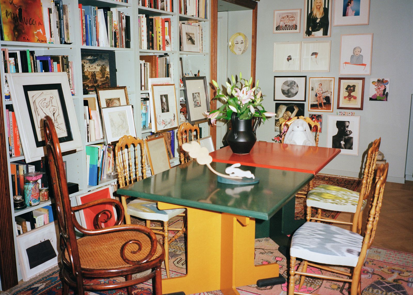 Soggiorno tavolo verde tavolo rosso sedie vaso con fiori libreria libri dipinti quadri