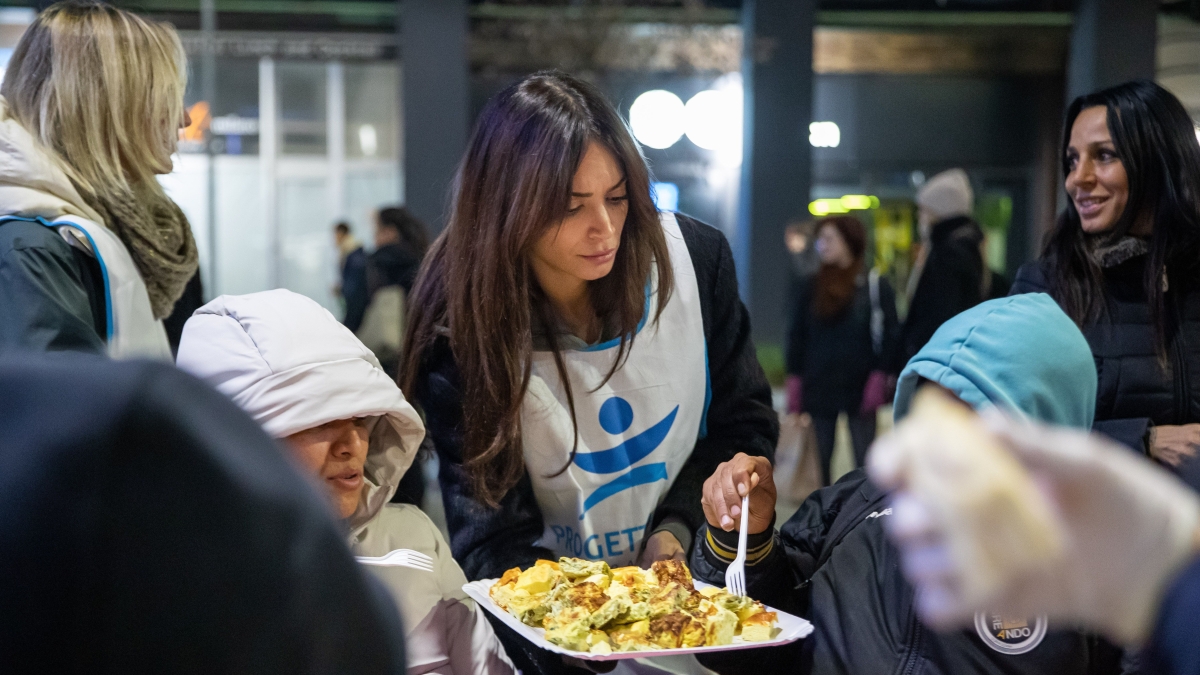 Elodie volontaria alla cena per i meno fortunati sotto i portici di piazza San Babila a Milano: tavolata per 100 persone, ne arrivano 150