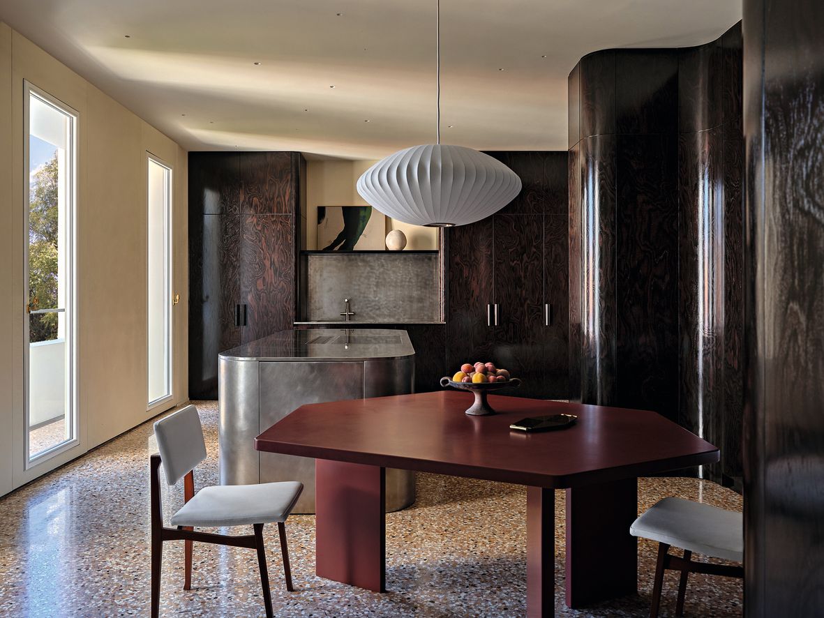 Cucina in legno tavolo irregolare rosso sedie lampadario isola in metallo