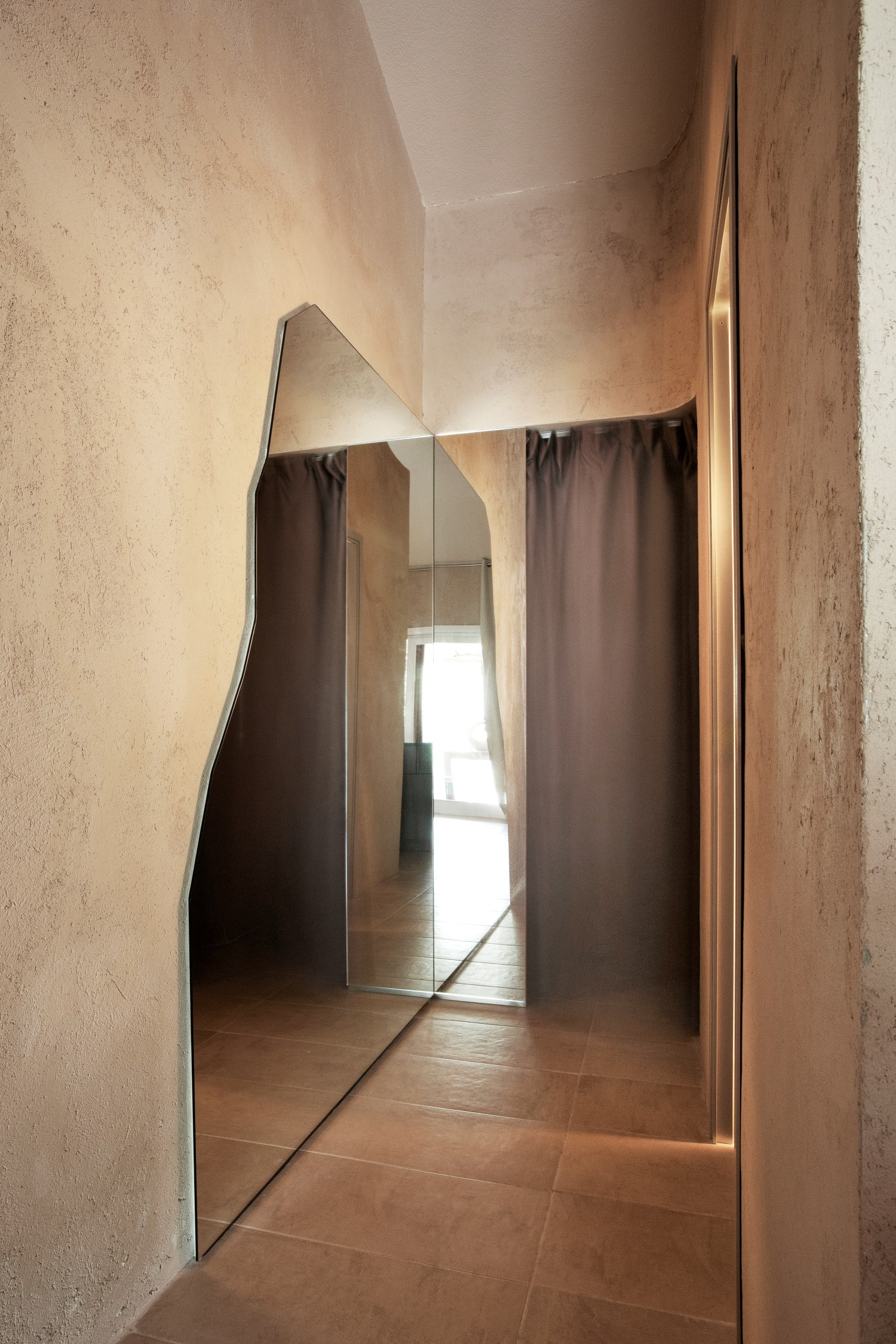 Corridoio con pareti beige e uno specchio a parete