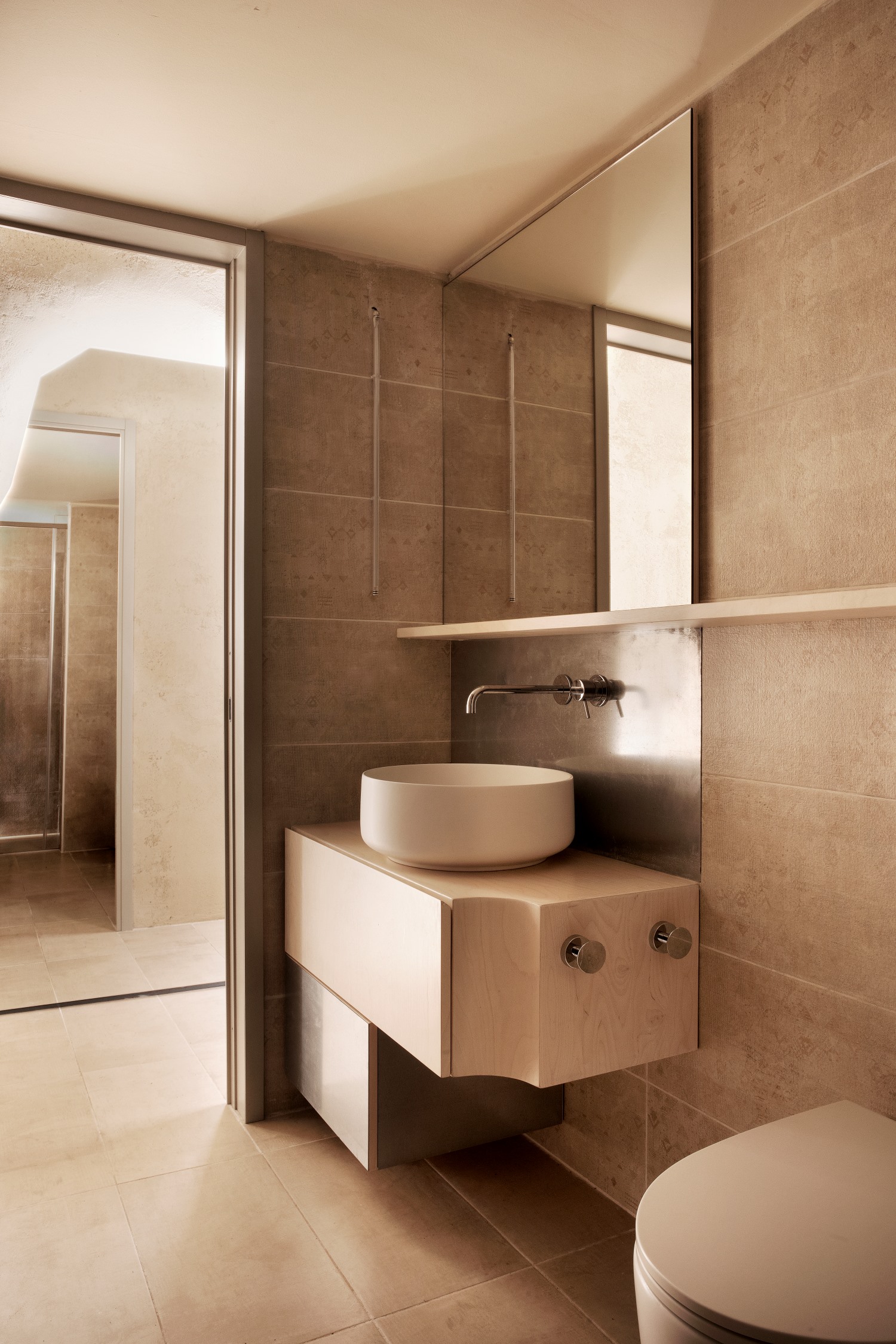 Bagno sui toni del beige, specchio quadrato, lavabo rotondo