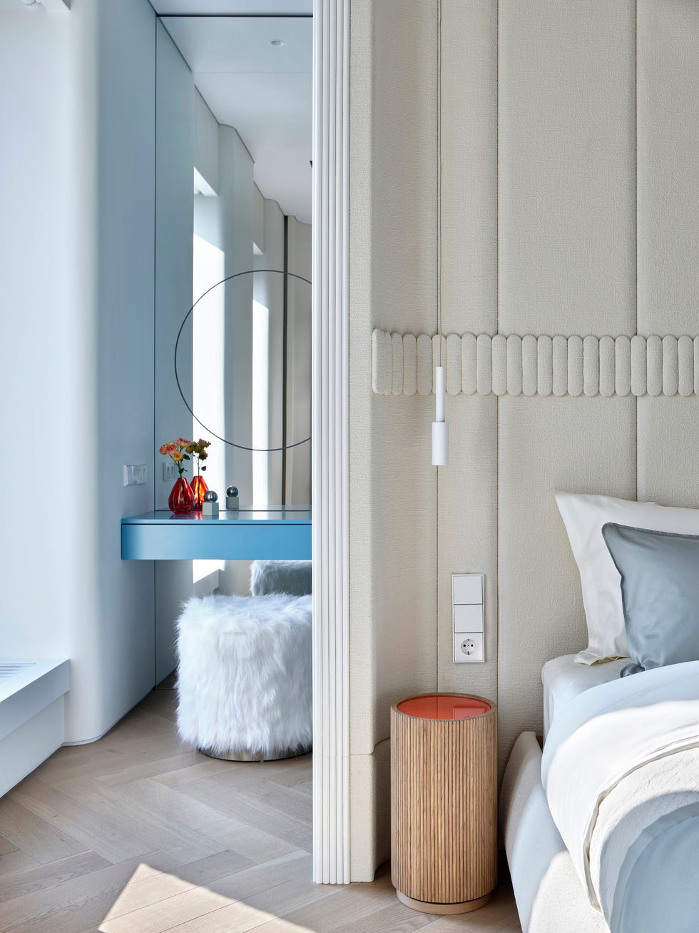 tocador azul y puf de pelo blanco