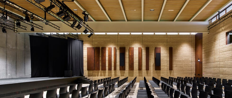 an auditorium with rows of chairs facing a stage