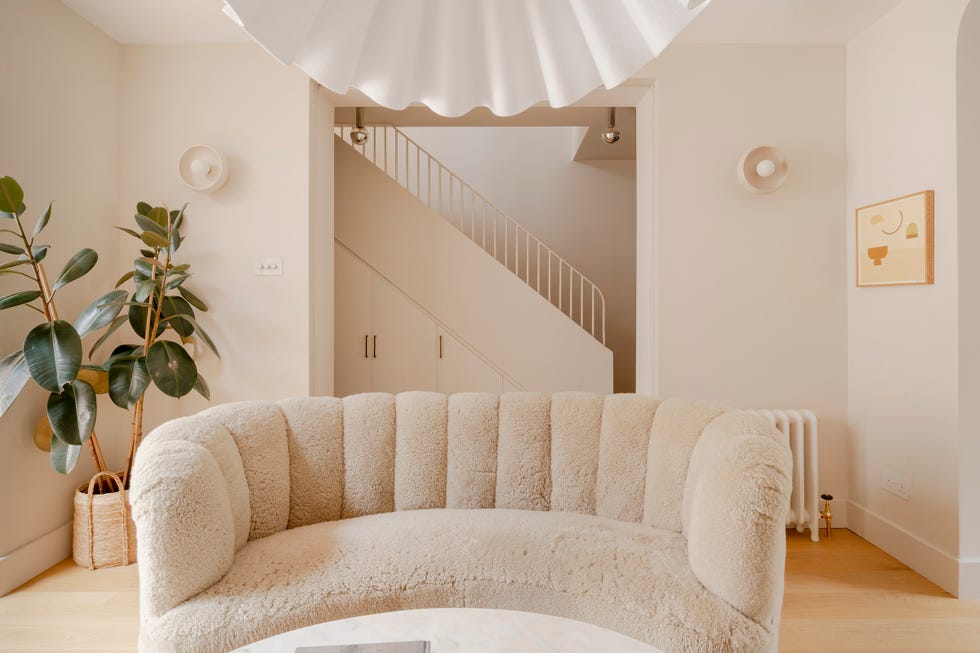 cozy living room setting with a curved sofa and staircase