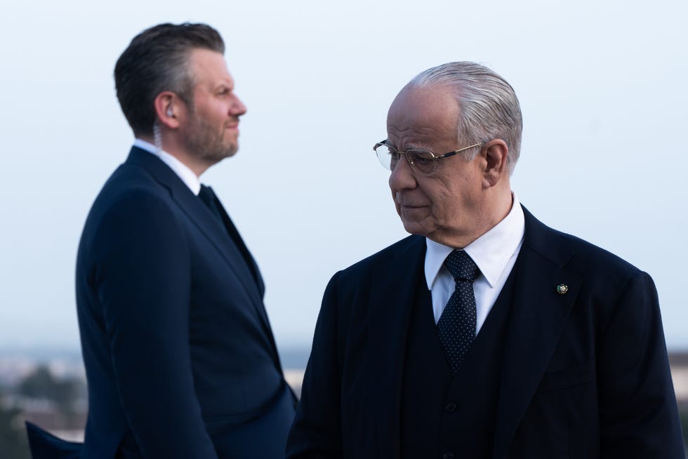 two welldressed individuals engaged in a serious conversation prominently displaying their formal attire