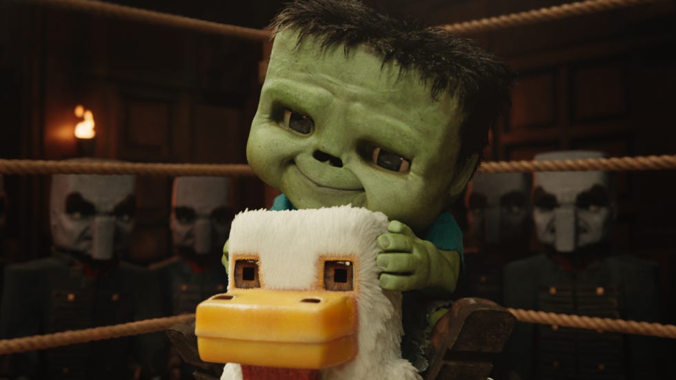 a toy character riding a plush duck in a dimly lit arena with spectators