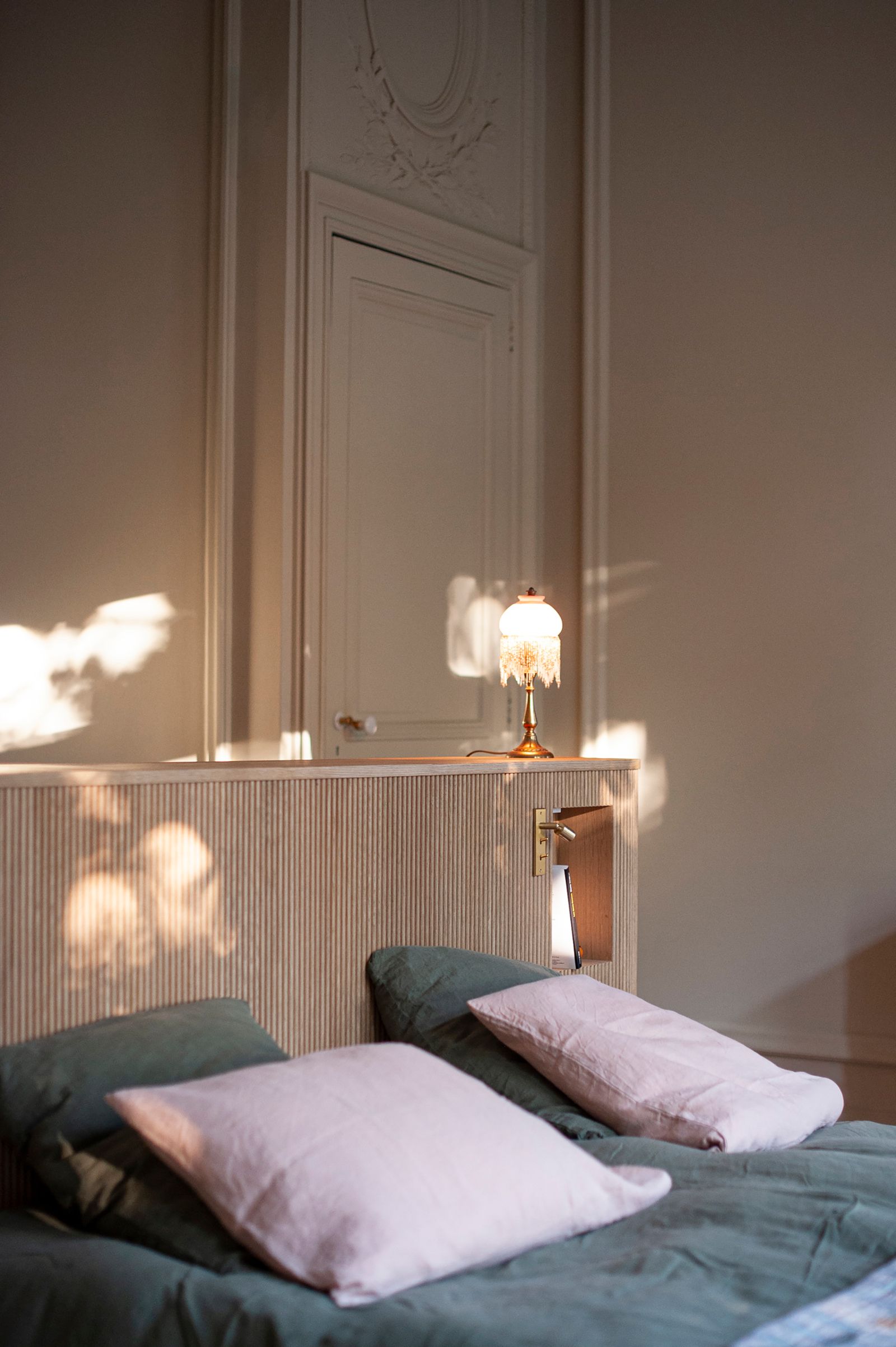 camera da letto porta con decorazione in gesso testata in legno scanalato