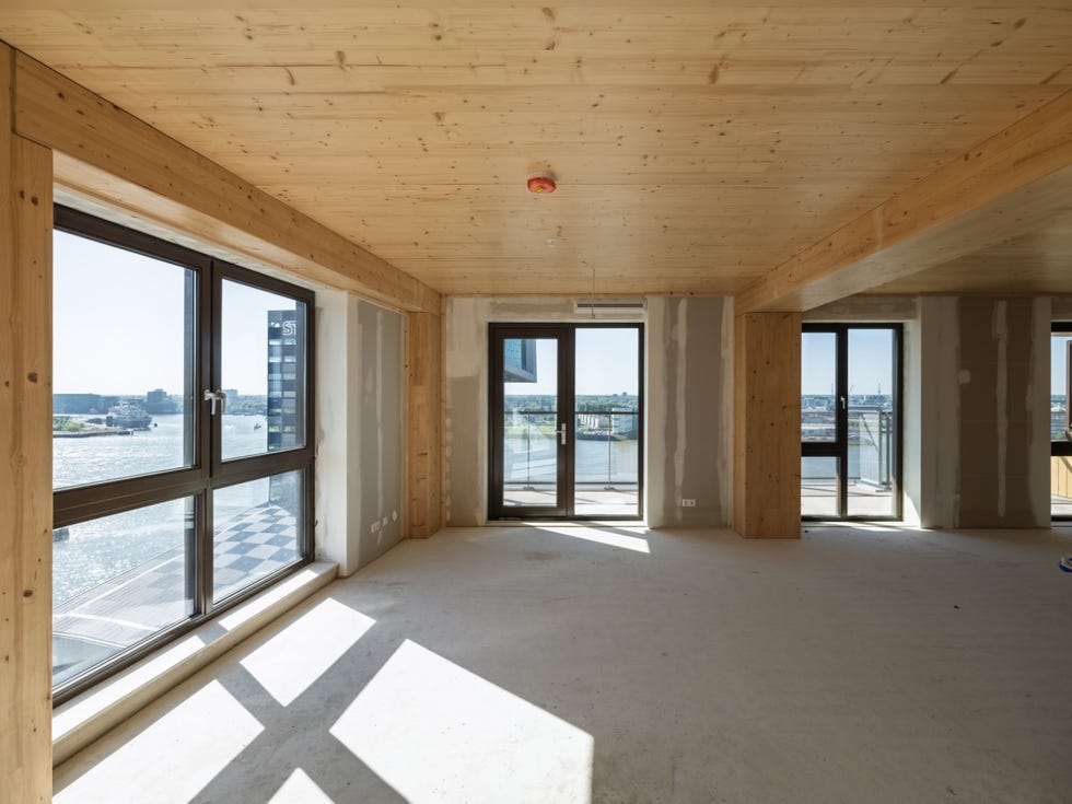 bright unfinished interior space with large windows and wooden beams