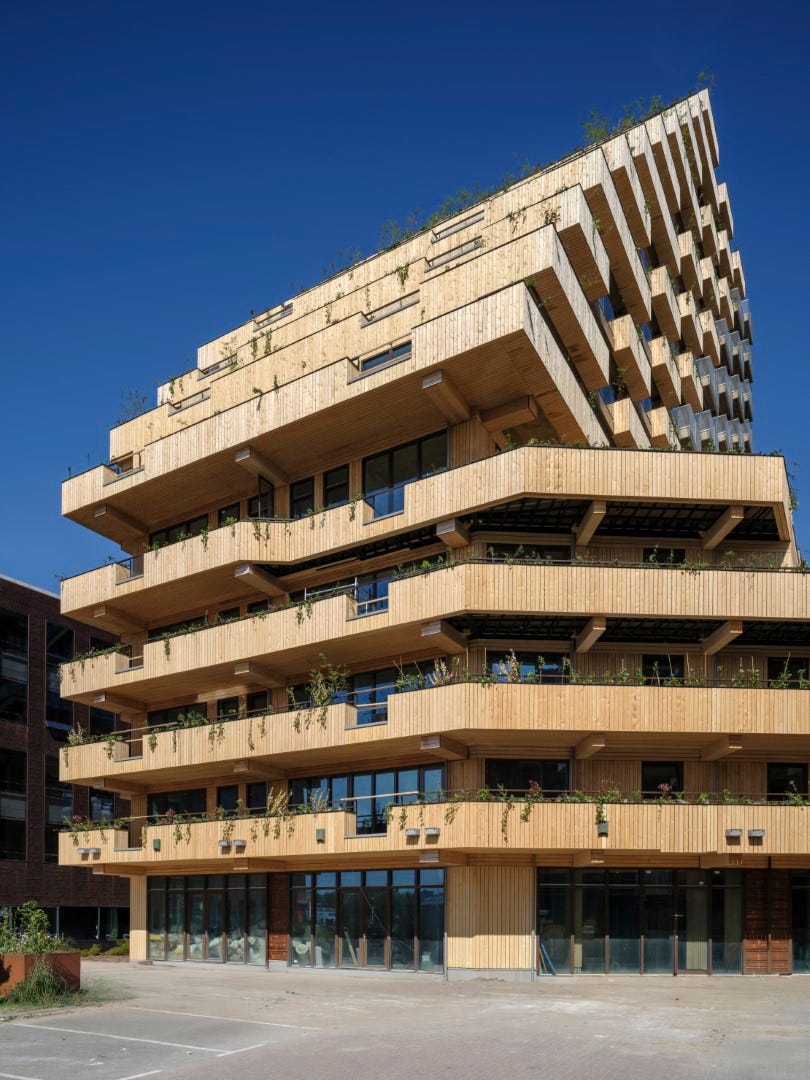 modern multistory wooden building with balconies and greenery