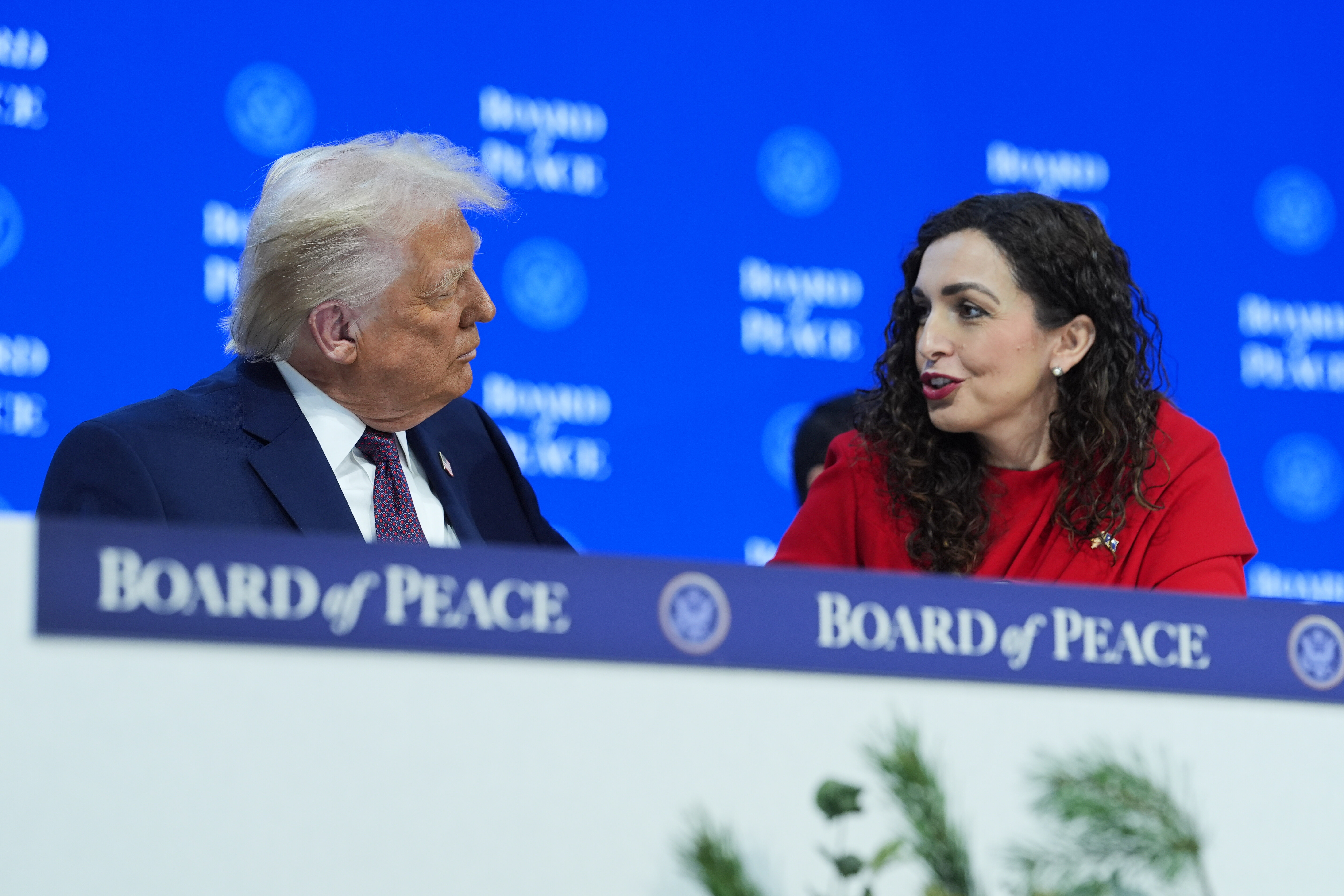 President Donald Trump, left, speaks with Kosovo's President Vjosa Osmani-Sadriu during a signing of the Board of Peace charter during the Annual Meeting of the World Economic Forum in Davos, Switzerland, Thursday, Jan. 22, 2026. (AP Photo/Evan Vu...