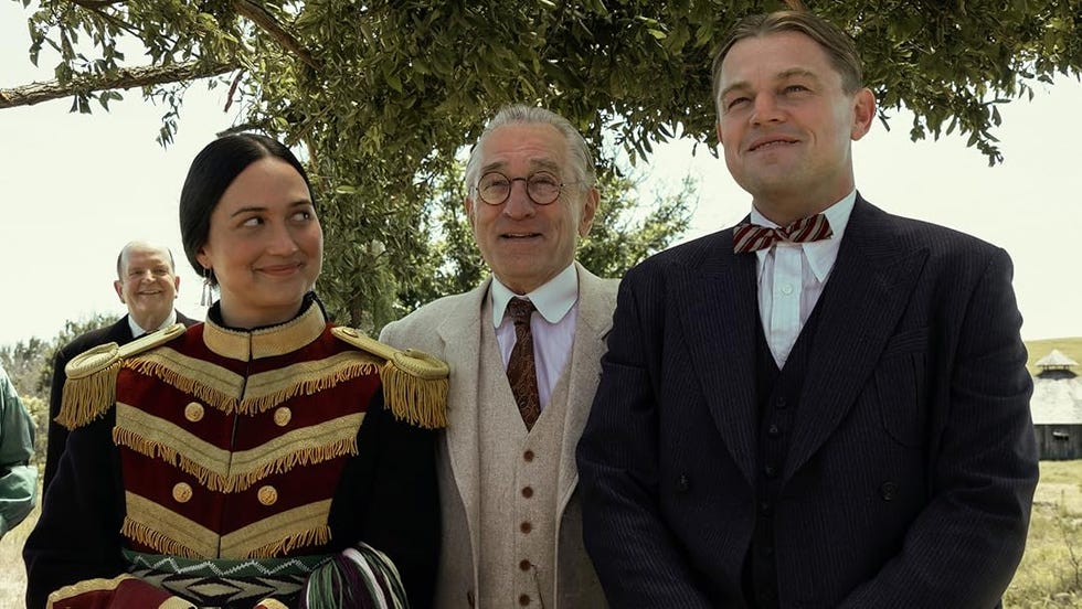 group of three individuals in historical attire outdoors standing under a tree group of three individuals in historical attire outdoors standing under a tree
