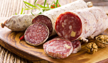 Salami tagliati su un tagliere; concept: salumi, salame, muffa, insaccati