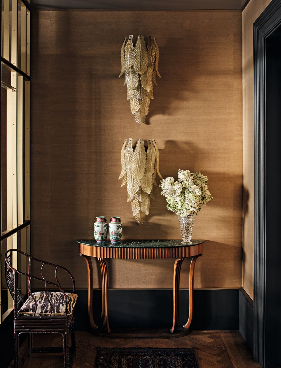 Corridoio applique a forma di foglie consolle in legno e marmo vaso con fiori sedia tappeto