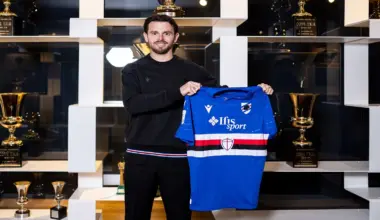 Un uomo sorridente mostra la maglia della Sampdoria