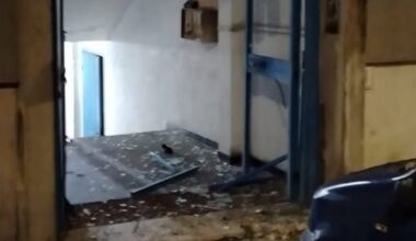 danneggiato portone del palazzo e auto in sosta