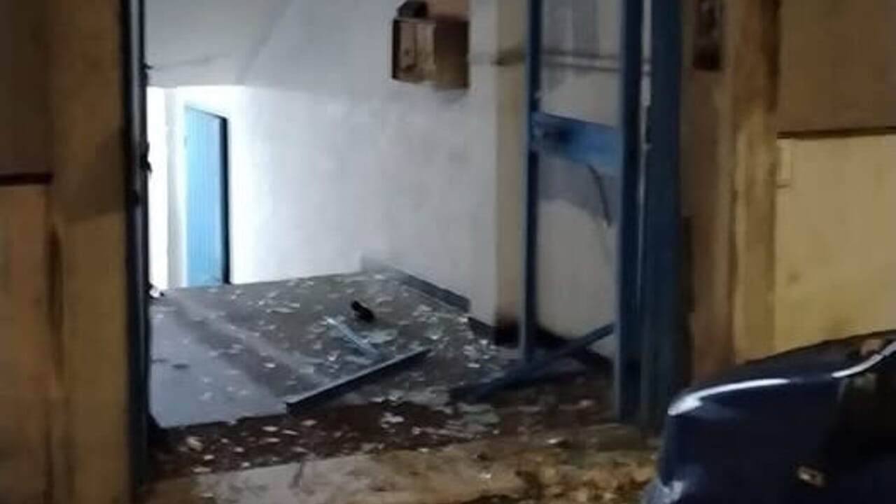 danneggiato portone del palazzo e auto in sosta