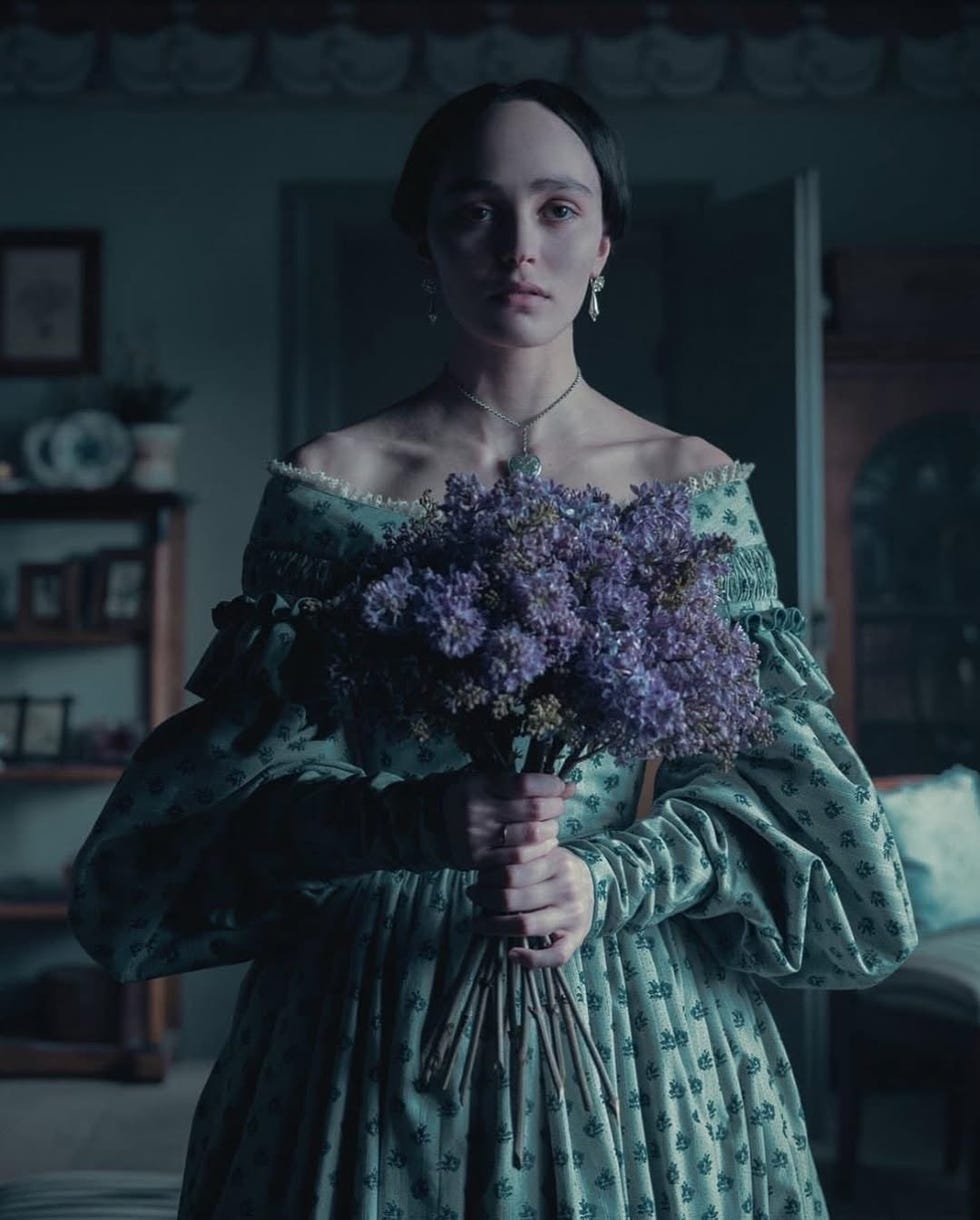 person holding a bouquet of lilacs in a vintage setting