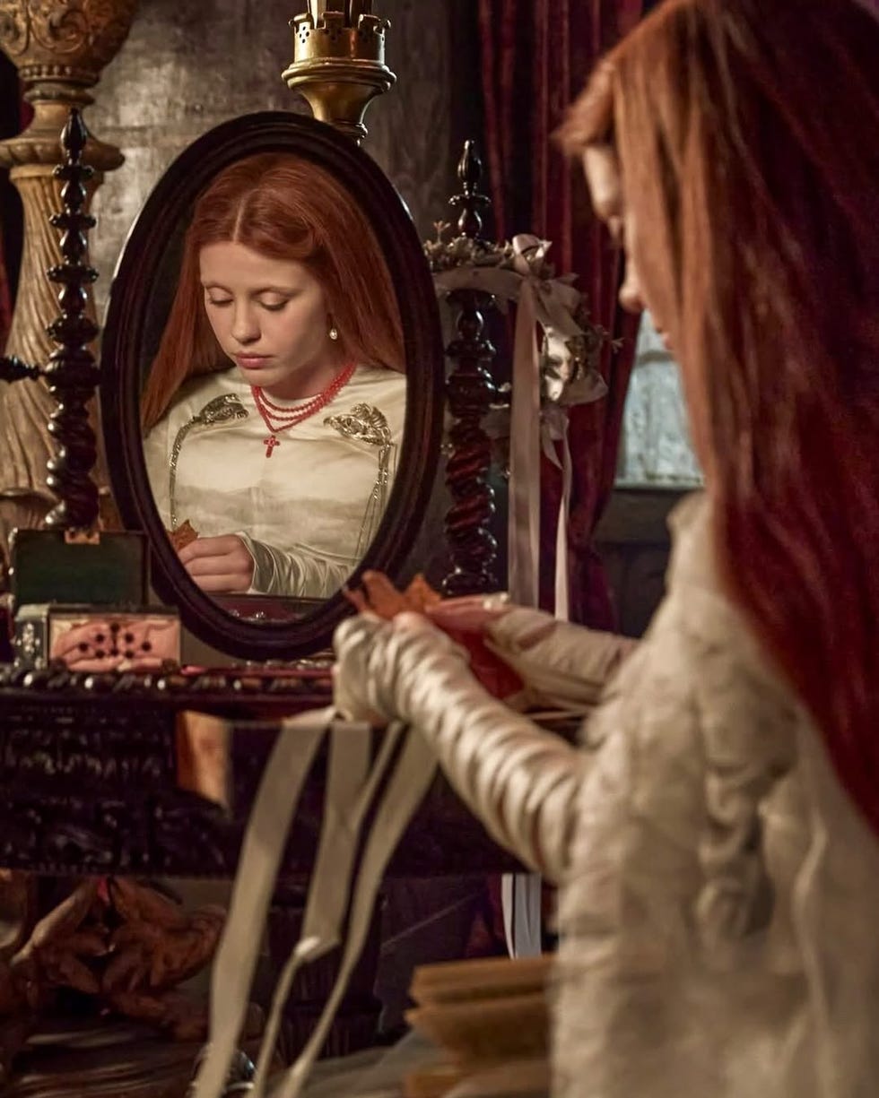 reflection in a mirror showing a person dressing with a vintage vanity setup