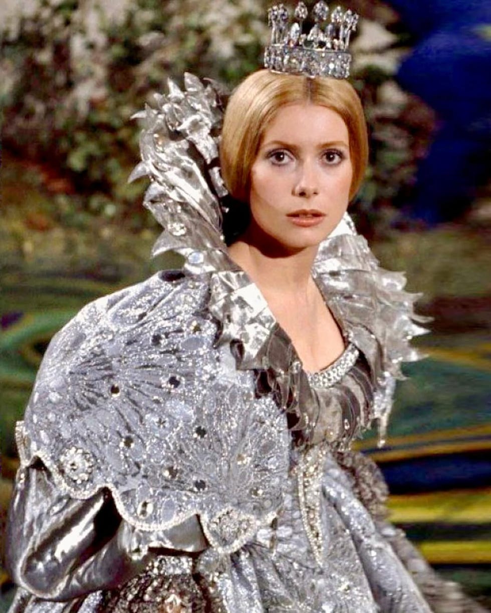 a figure in an ornate silver gown and crown