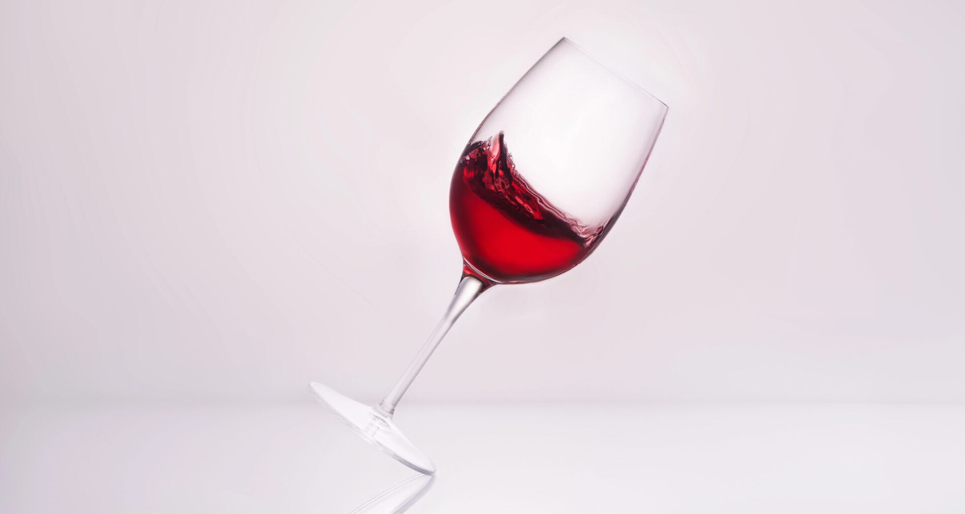 Bicchiere di vino rosso inclinato; concept: alcol, bevande alcoliche