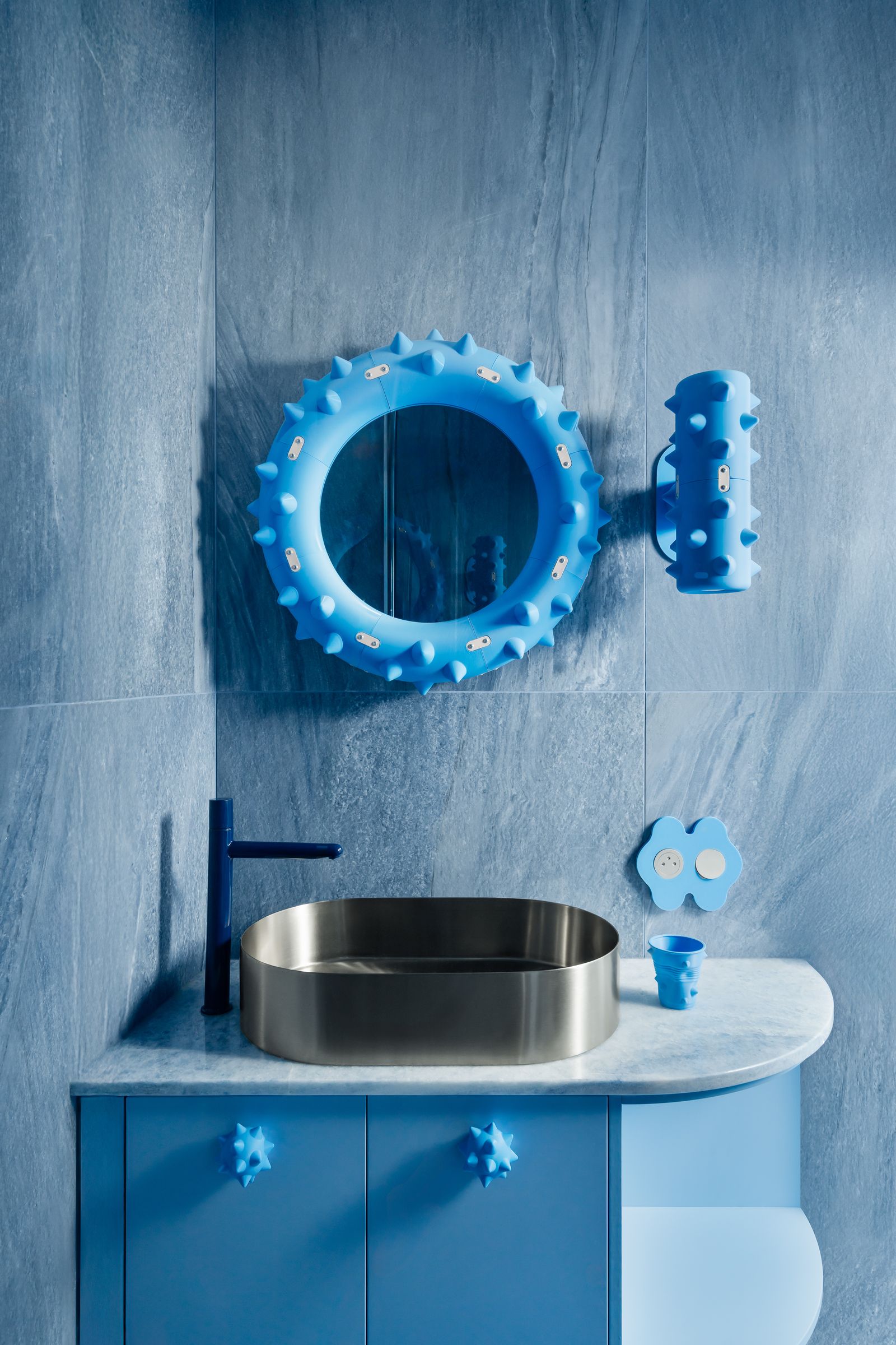 bagno mobile azzurro con pomelli a forma di riccio lavabo in metallo applique e specchio con spuntoni