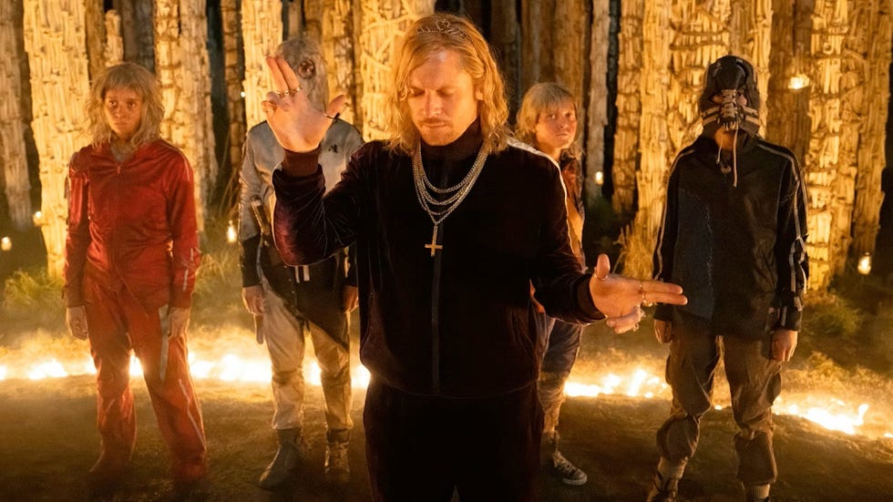 group of individuals standing in a forest setting with candles group of individuals standing in a forest setting with candles