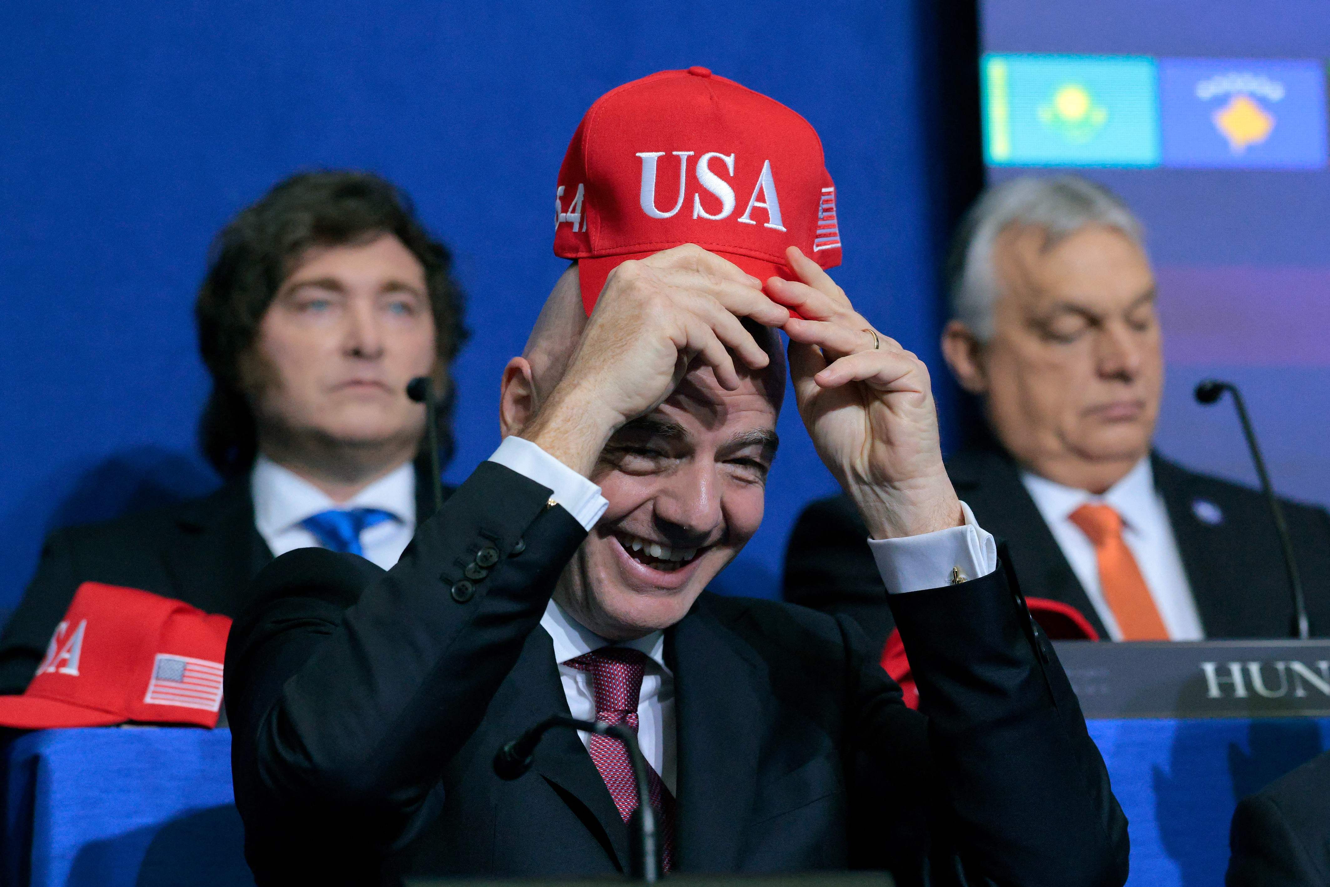 WASHINGTON, DC - FEBRUARY 19: President of FIFA Gianni Infantino holds up a USA hat as he attends the inaugural meeting of the Board of Peace at the Institute of Peace on February 19, 2026 in Washington, DC. Assembled to raise money for the rebuil...