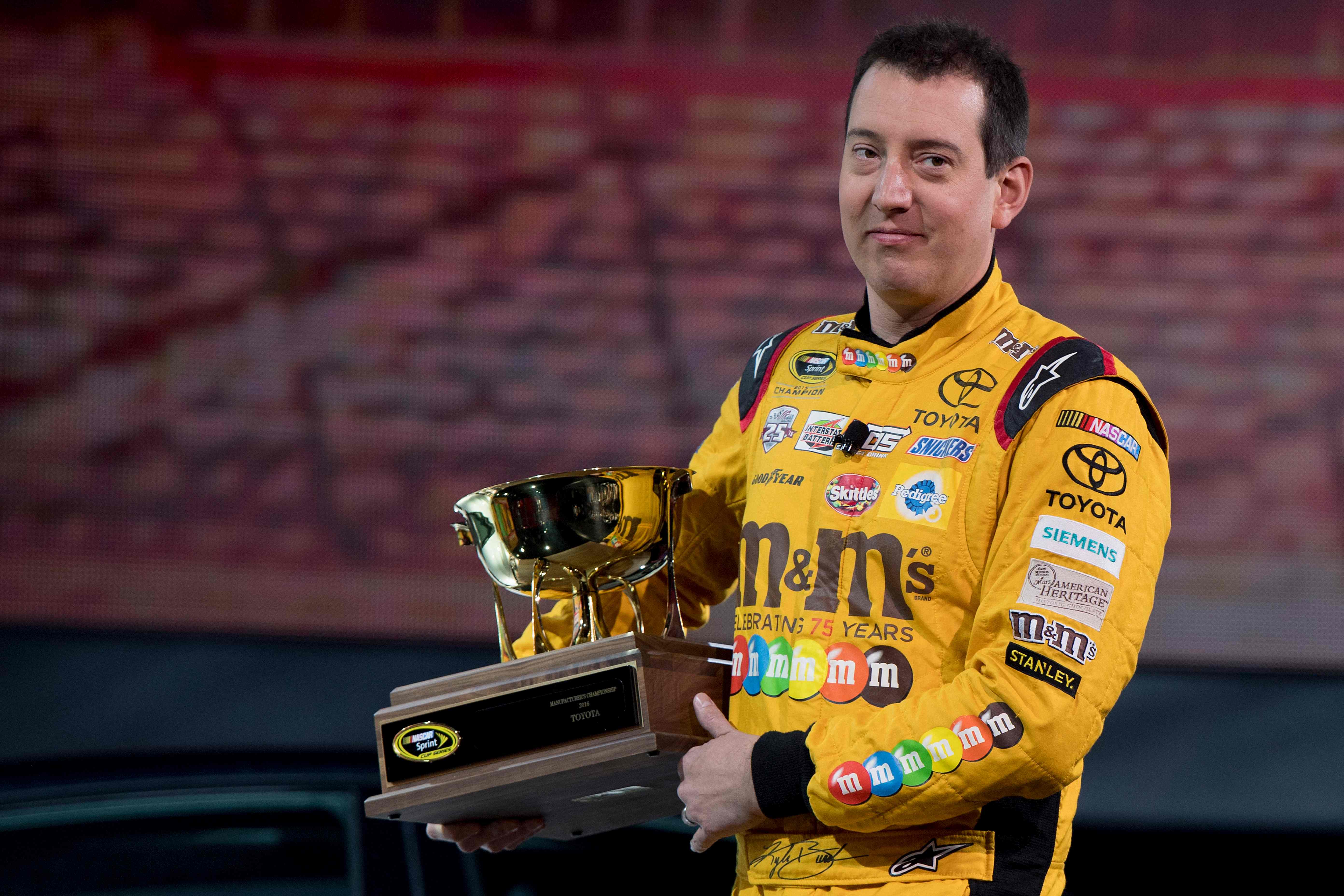 (FILES) 2015 NASCAR Sprint Cup Series Champion Kyle Busch carries the 2016 NASCAR Manufacturers Trophy at the Toyota press conference during the 2017 North American International Auto Show in Detroit, Michigan, on January 9, 2017. NASCAR star Kyle...
