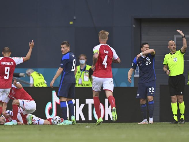 Copenaghen, 12 giugno 2021: l’arbitro Anthony Taylor, a destra, chiama i soccorsi mentre, a sinistra, Simon Kjaer sta soccorrendo Christian Eriksen crollato a terra (Ap)