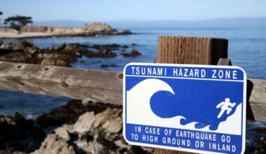 A tsunami warning sign advising people to head to higher ground or inland.